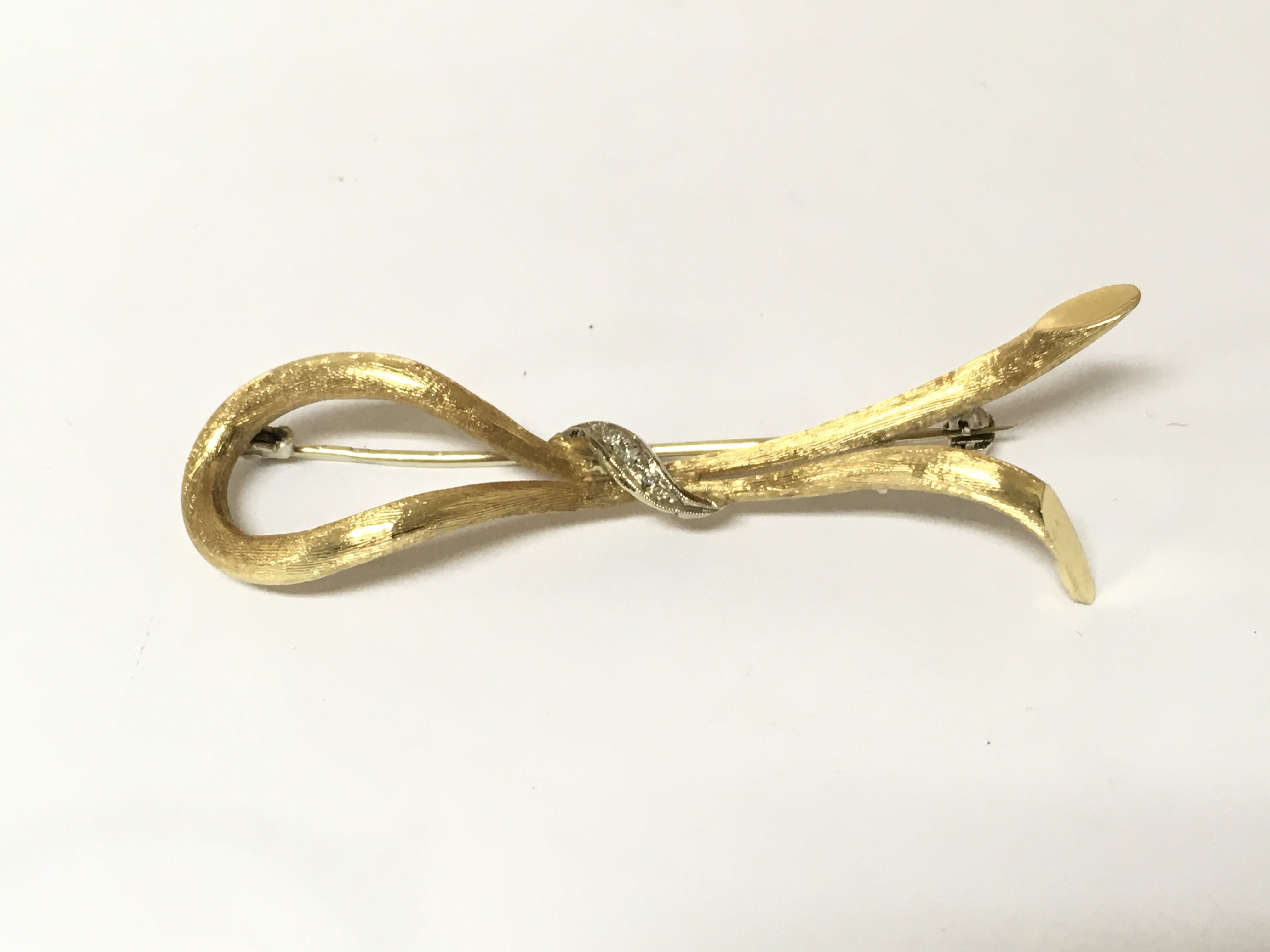 An 18ct gold brooch set with diamonds. 6.84g Postage B