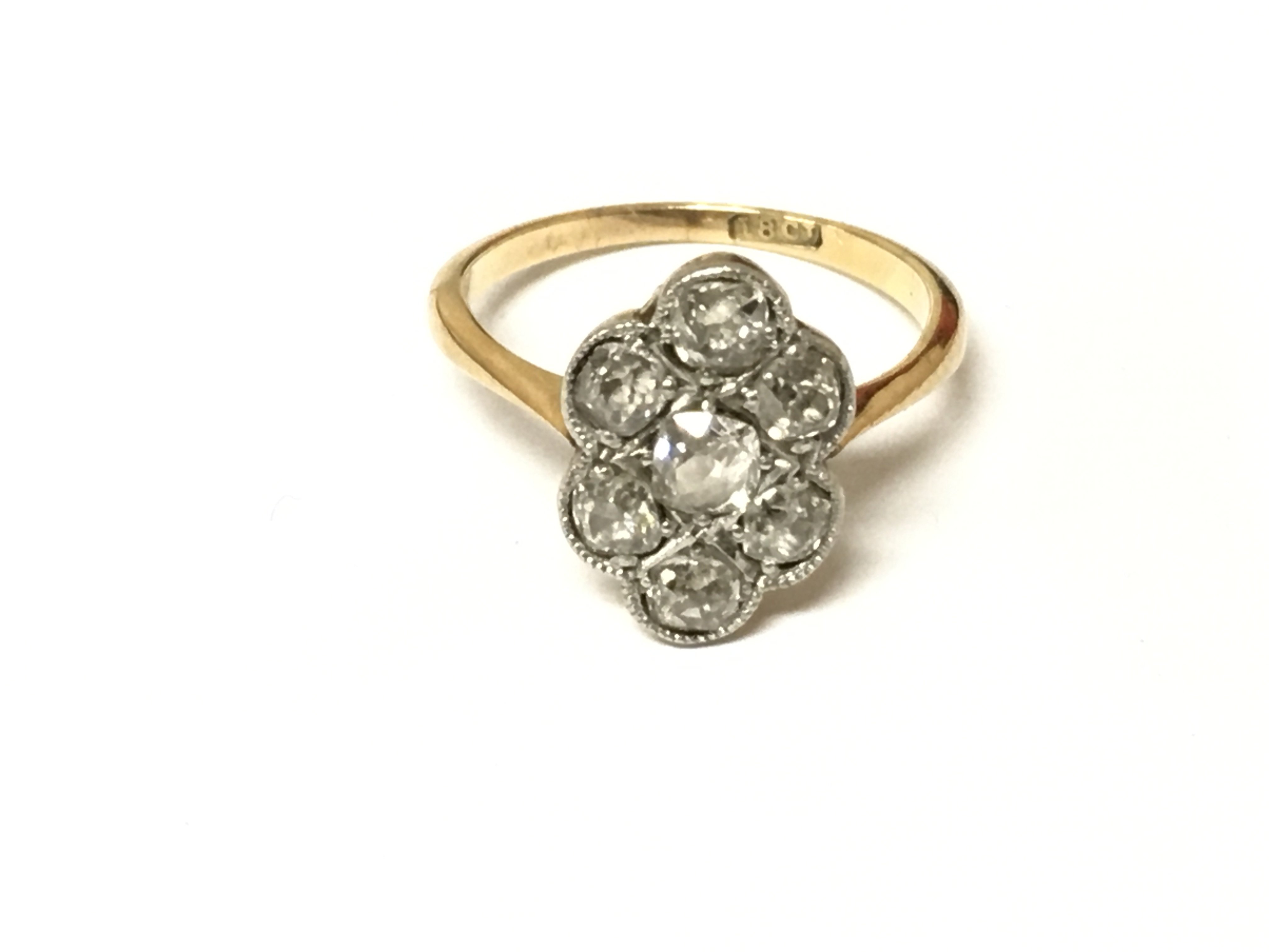 An 18ct gold 7 stone old cut diamond cluster ring. Size K and 2.76g