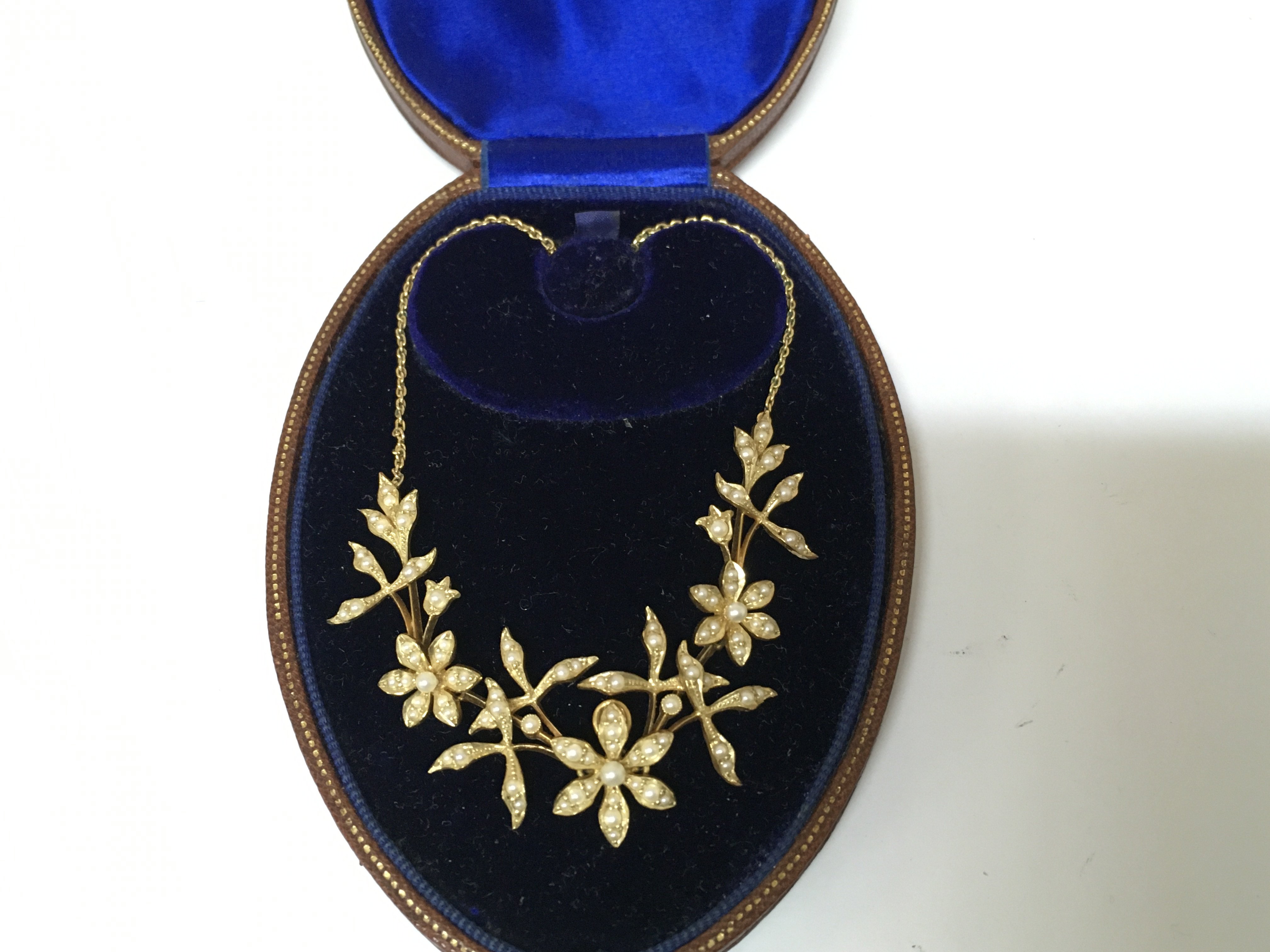 An Edwardian 15ct fiori design seed pearl necklace. 12g Postage B