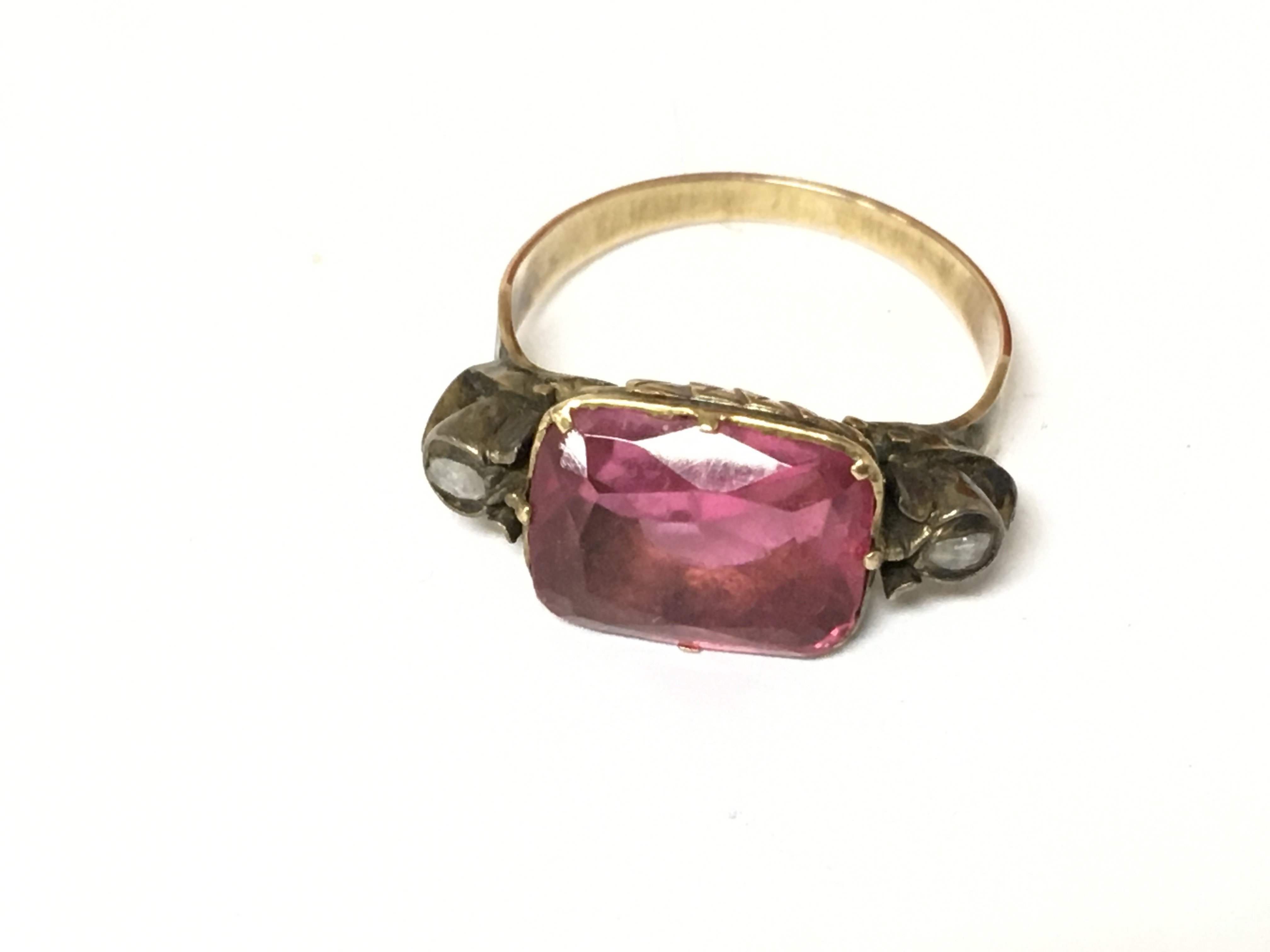 An unmarked yellow metal ring set with tourmaline and rose cut diamonds. Size K and 3.79g