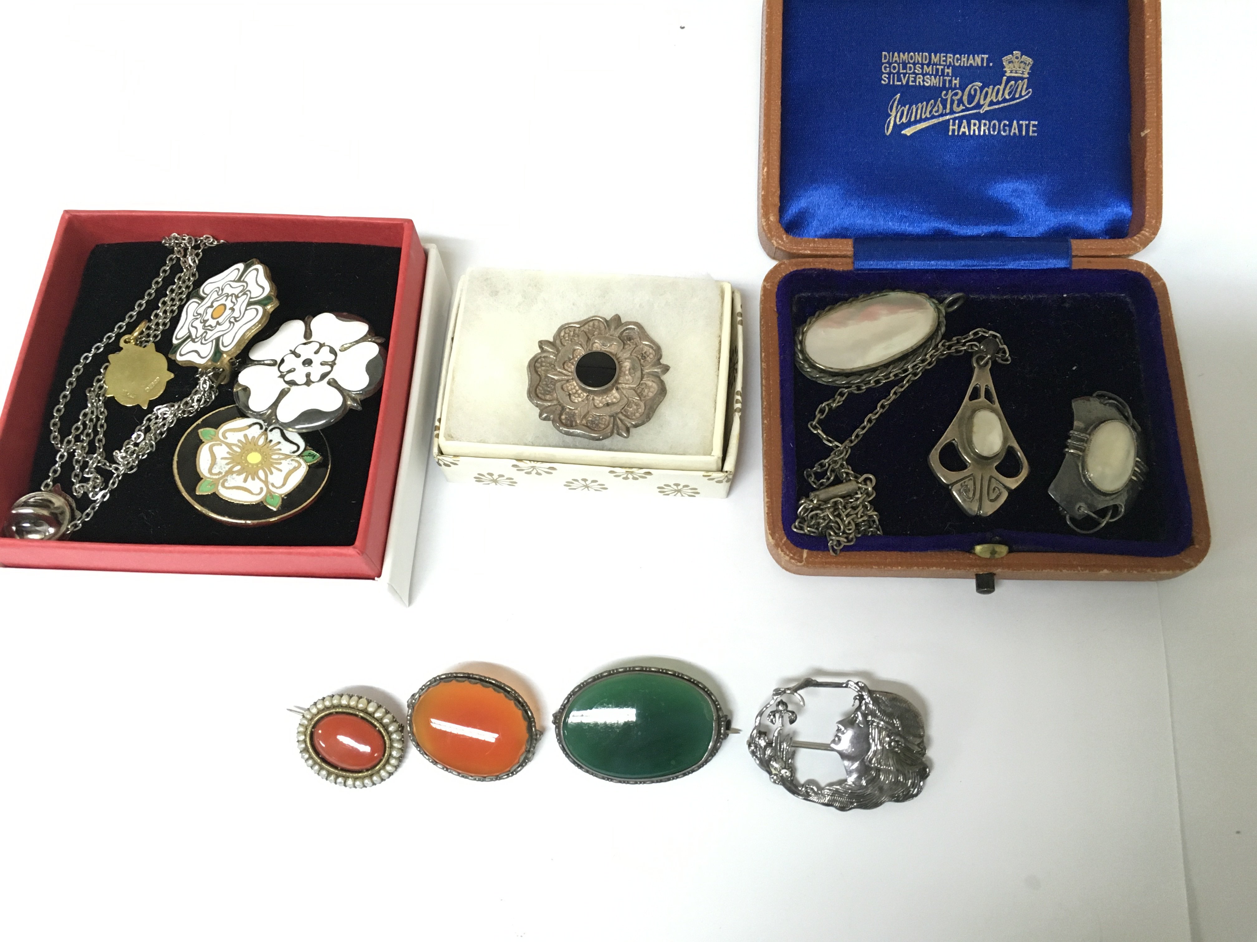 A collection of assorted silver brooches.