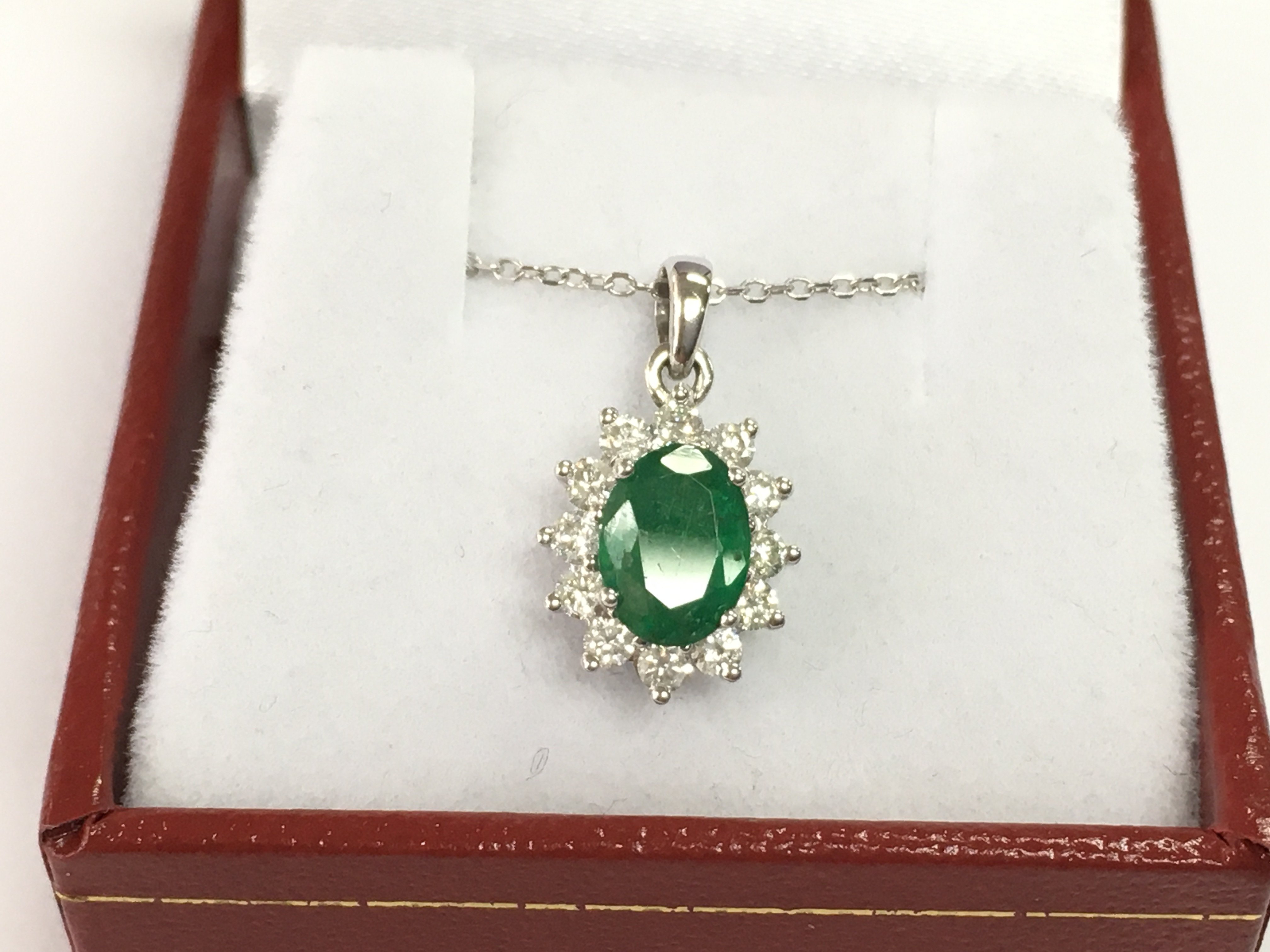 An 18ct white gold emerald and diamond pendant on an 18ct white gold chain. Emerald 0.86ct and diamonds 0.37ct.