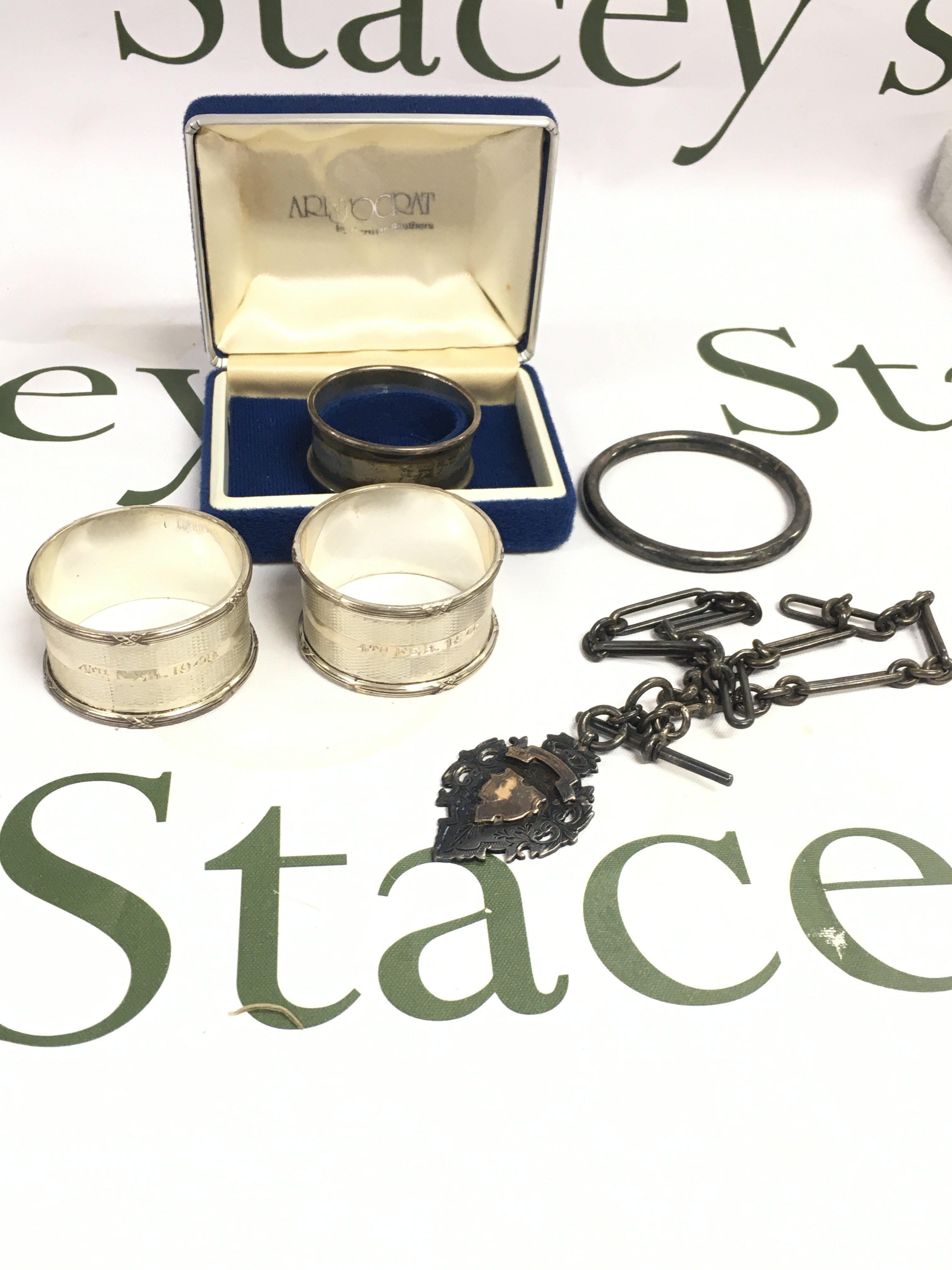 A small collection of silver items including Napkin rings, Pendants, watch chain etc. postage category B