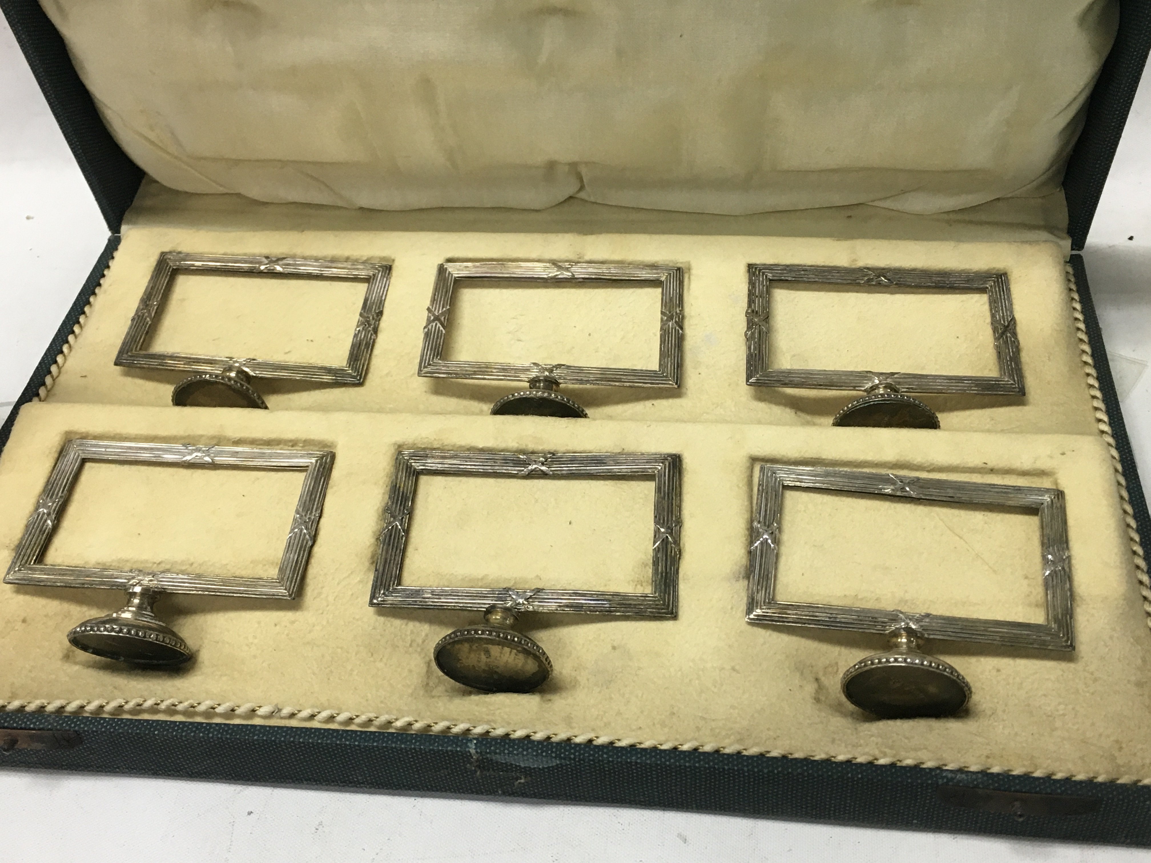 A cased set of six silver card holders marked 900 ( one damaged ) .