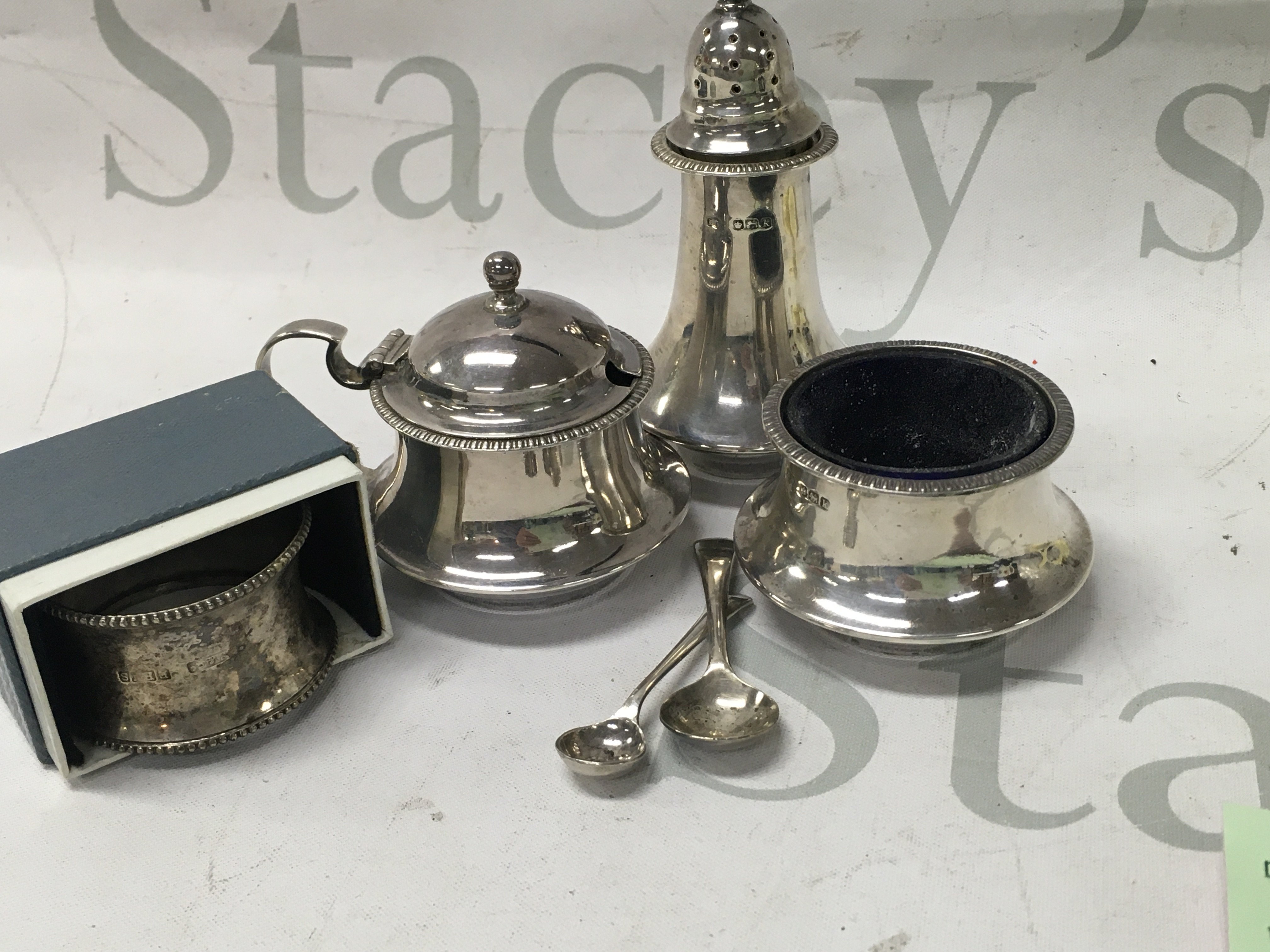 A silver condiment set and a silver napkin.