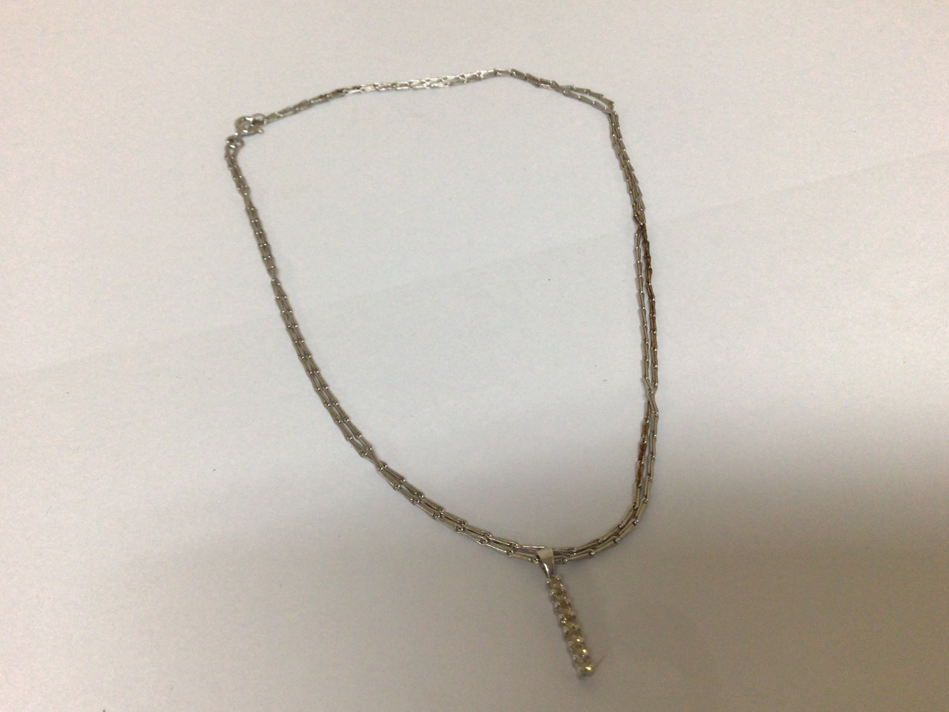 A 9carat white gold necklace with an unmarked modern design vertical drop pendent attached length of chain 76cm approximately weight 5.9g approximately.