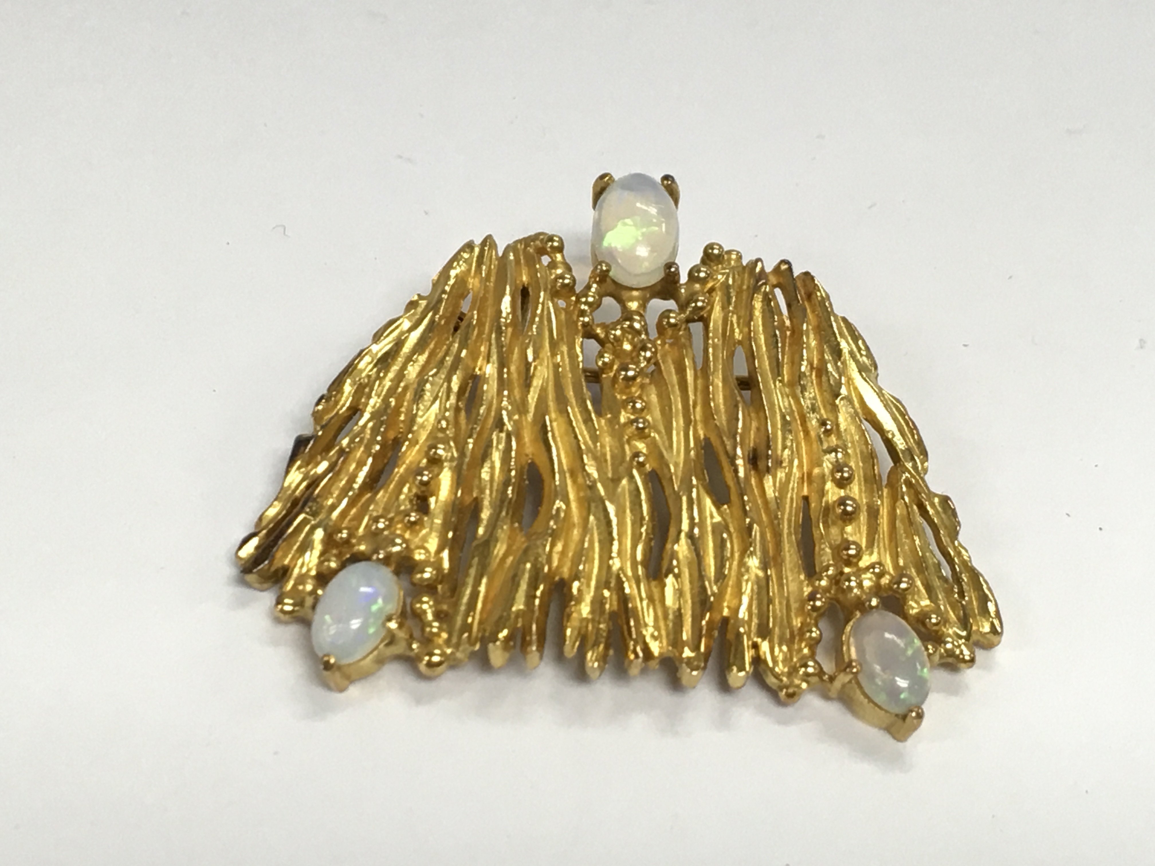 An unmarked gold brooch set with three opal stones. Approximately 4cm wide and 16.20g