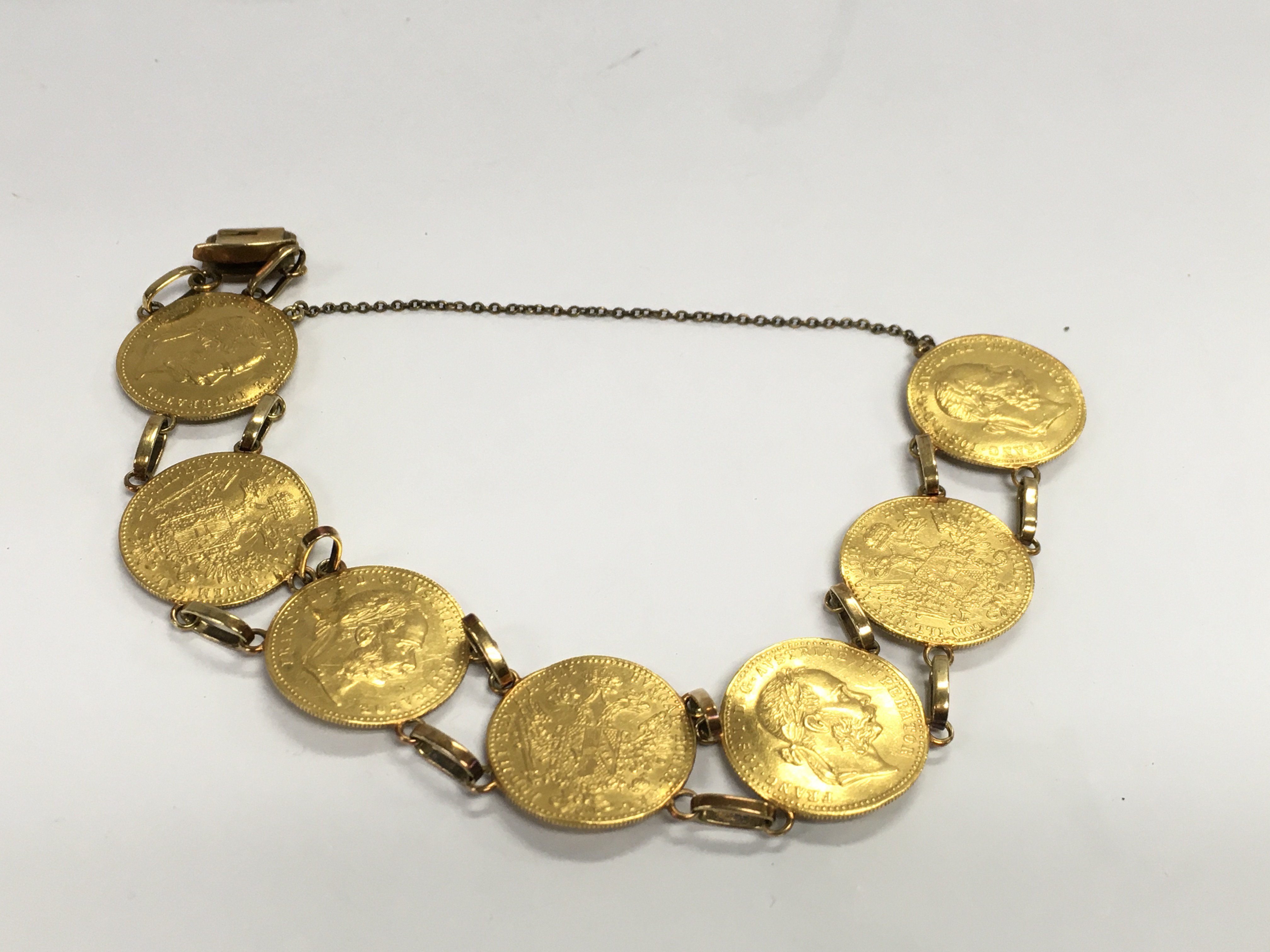 A gold bracelet made up of 7 ducat coins with 14ct links. Total weight approximately 30.75g