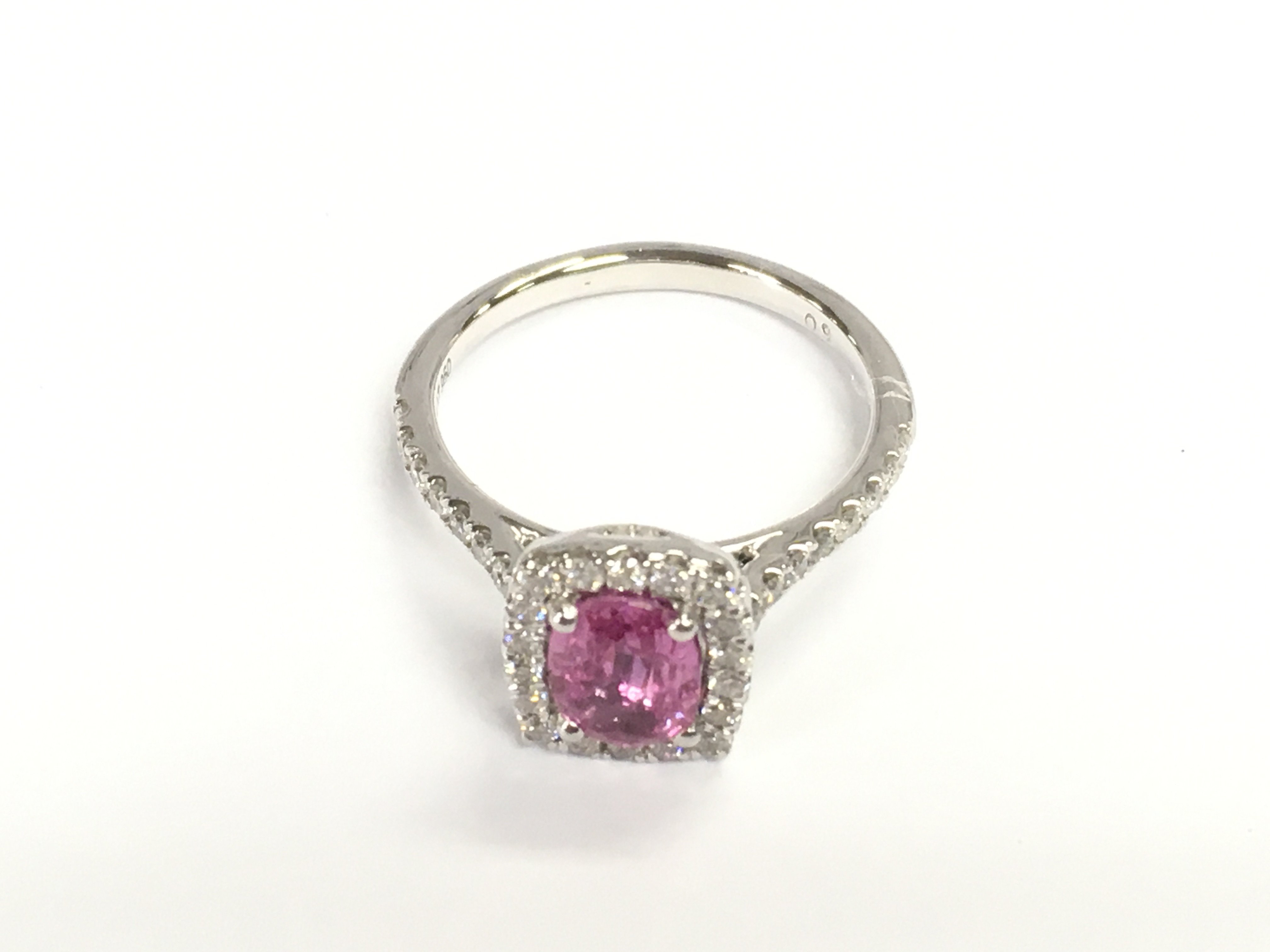 Platinum ring set with oval pink sapphire surrounded by diamonds and further diamonds set in shoulders. Sapphire 1.24ct and diamonds 0.41ct. Size N 1/2 approximately.