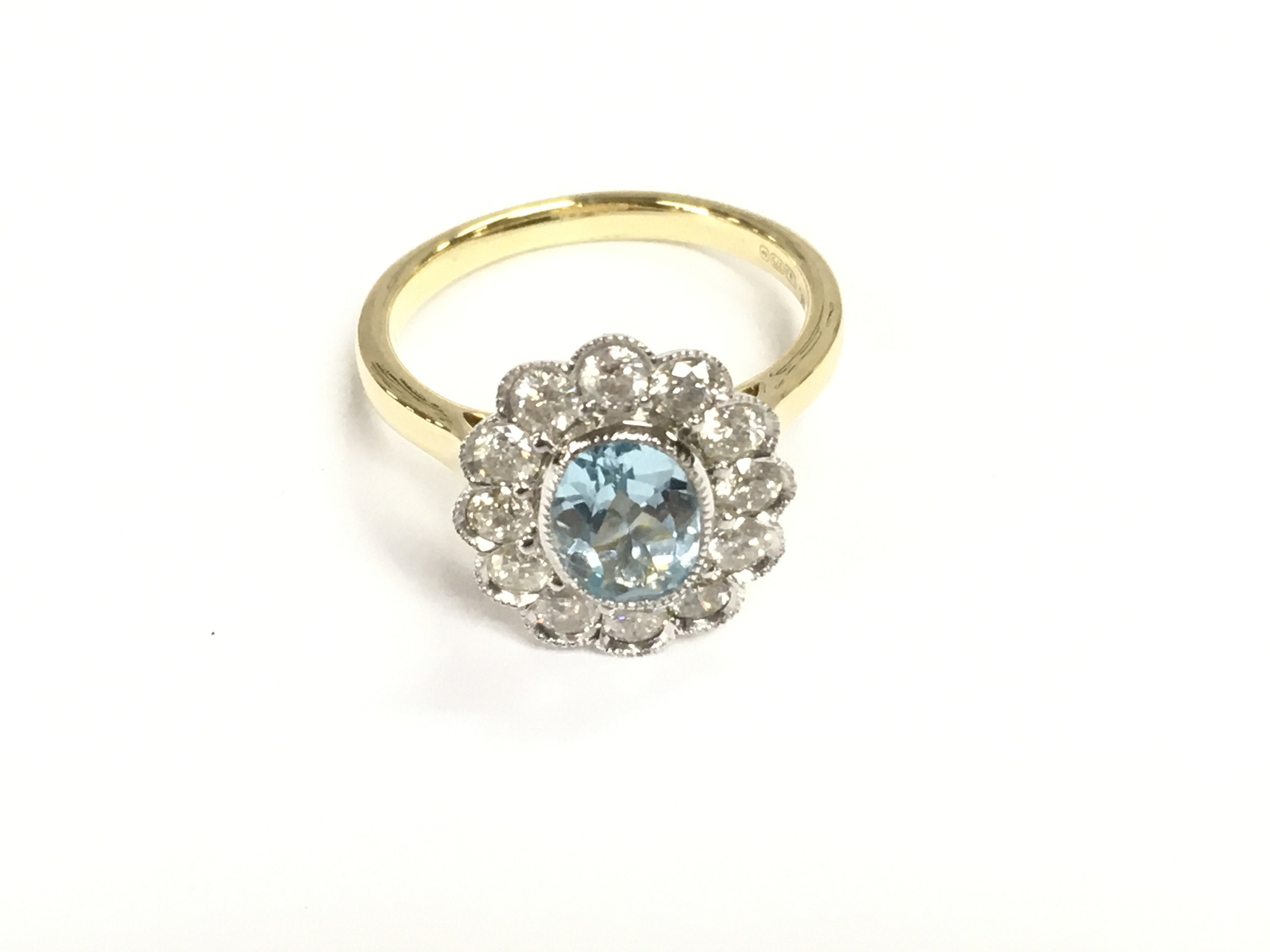 9ct yellow and white gold oval Swiss blue topaz and diamonds daisy cluster ring with scalloped finish. Topaz 1.40ct and diamonds 0.98ct size P.
