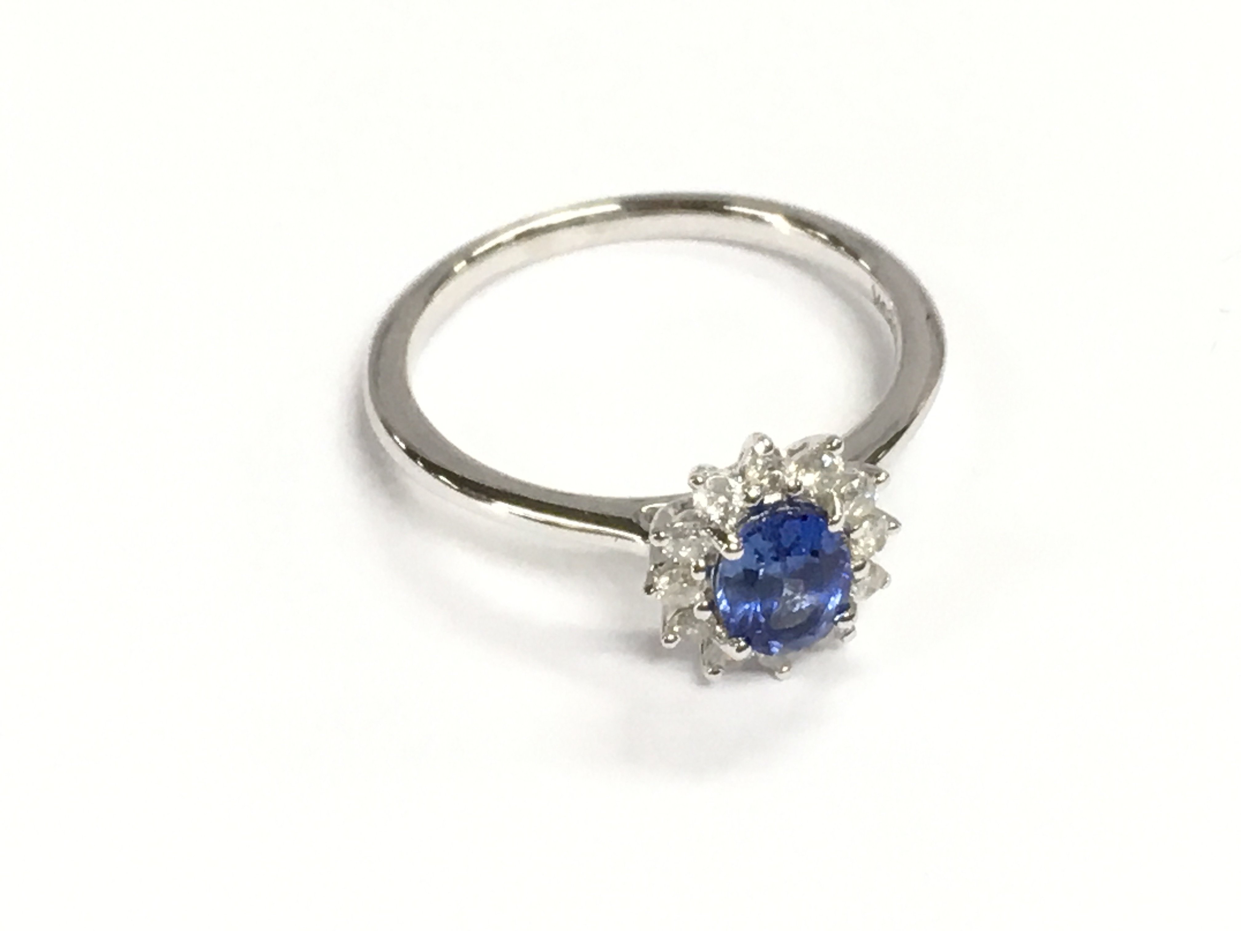 9ct white gold oval sapphire and diamond cluster ring. Sapphire 0.49ct and diamonds 0.19ct. Size M