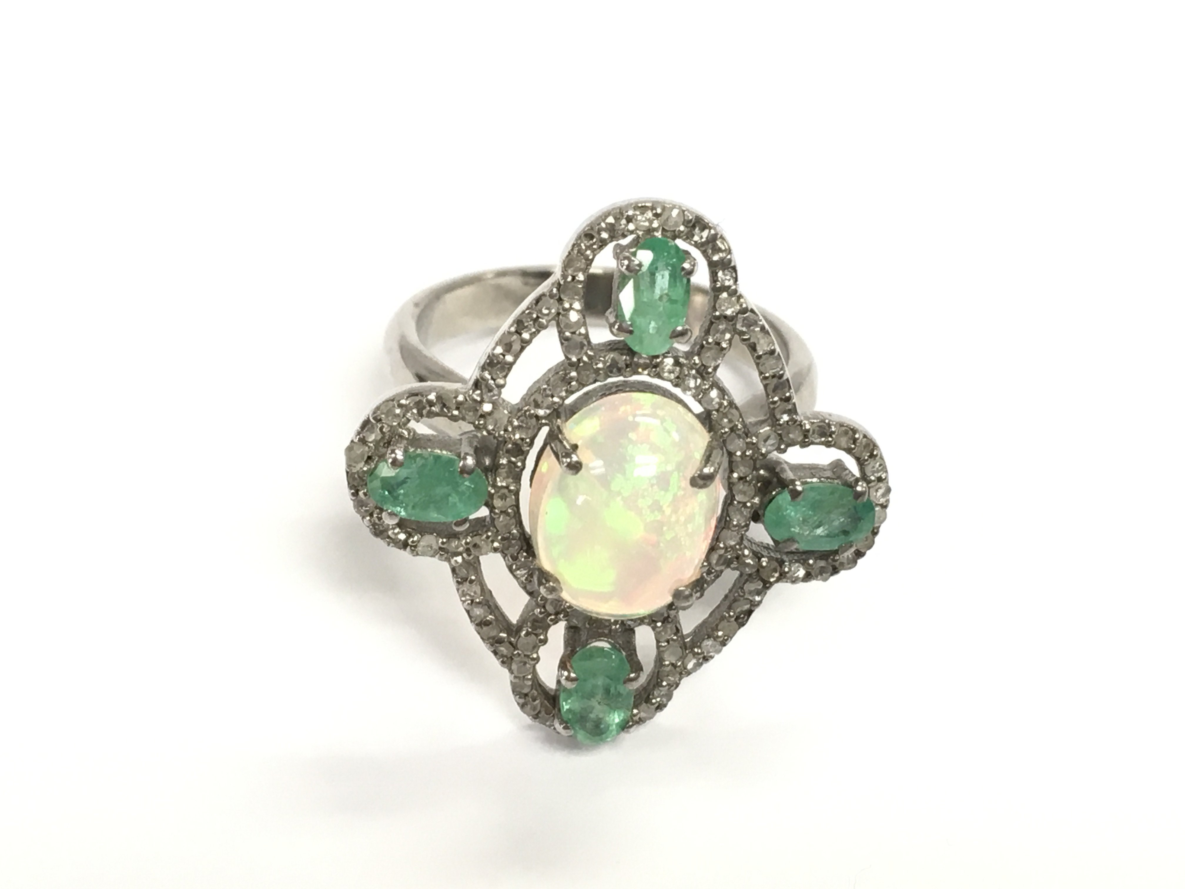 Silver dress ring set with an oval cabochon opal oval emeralds and diamonds. Opal 1.5ct emeralds 1ct and diamonds 0.60ct approximately. Size P
