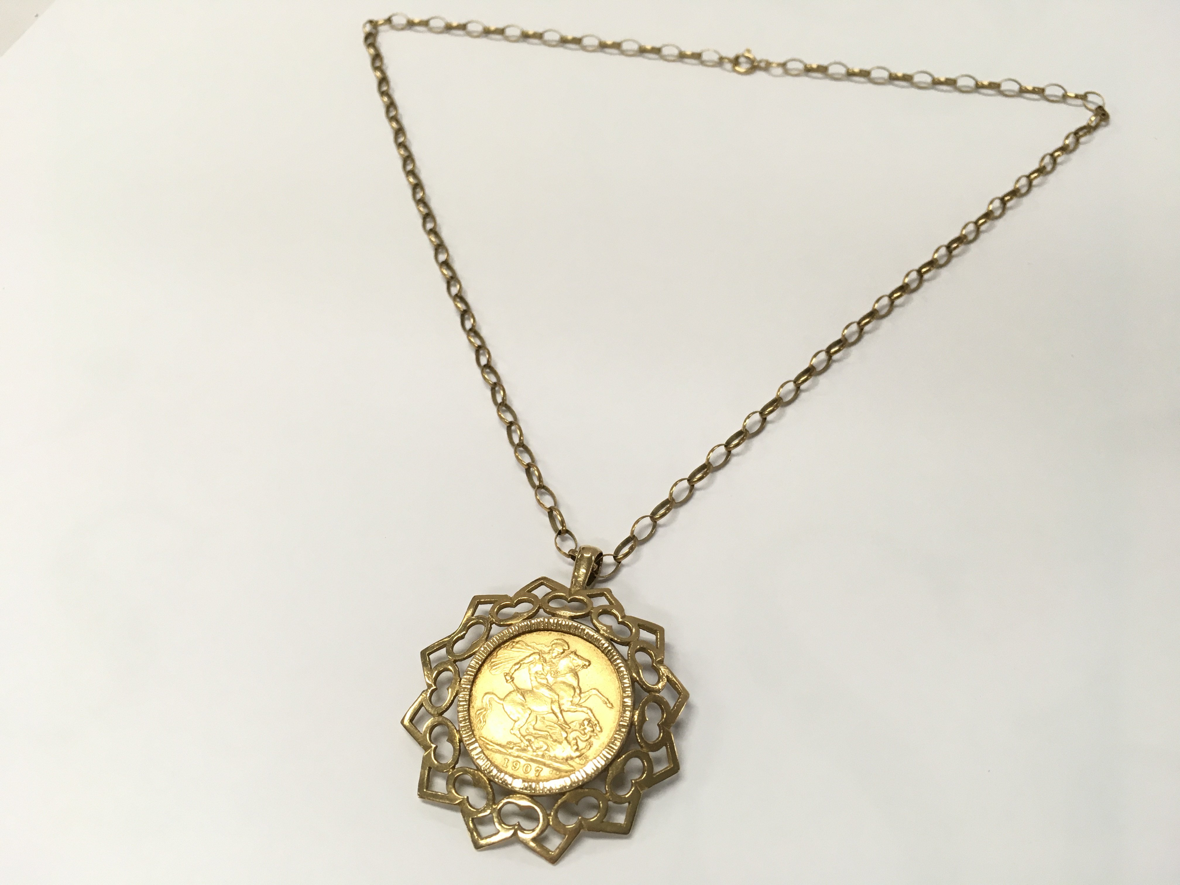 A 1907 full sovereign with mount and chain , 16.2g total weight. Postage category A