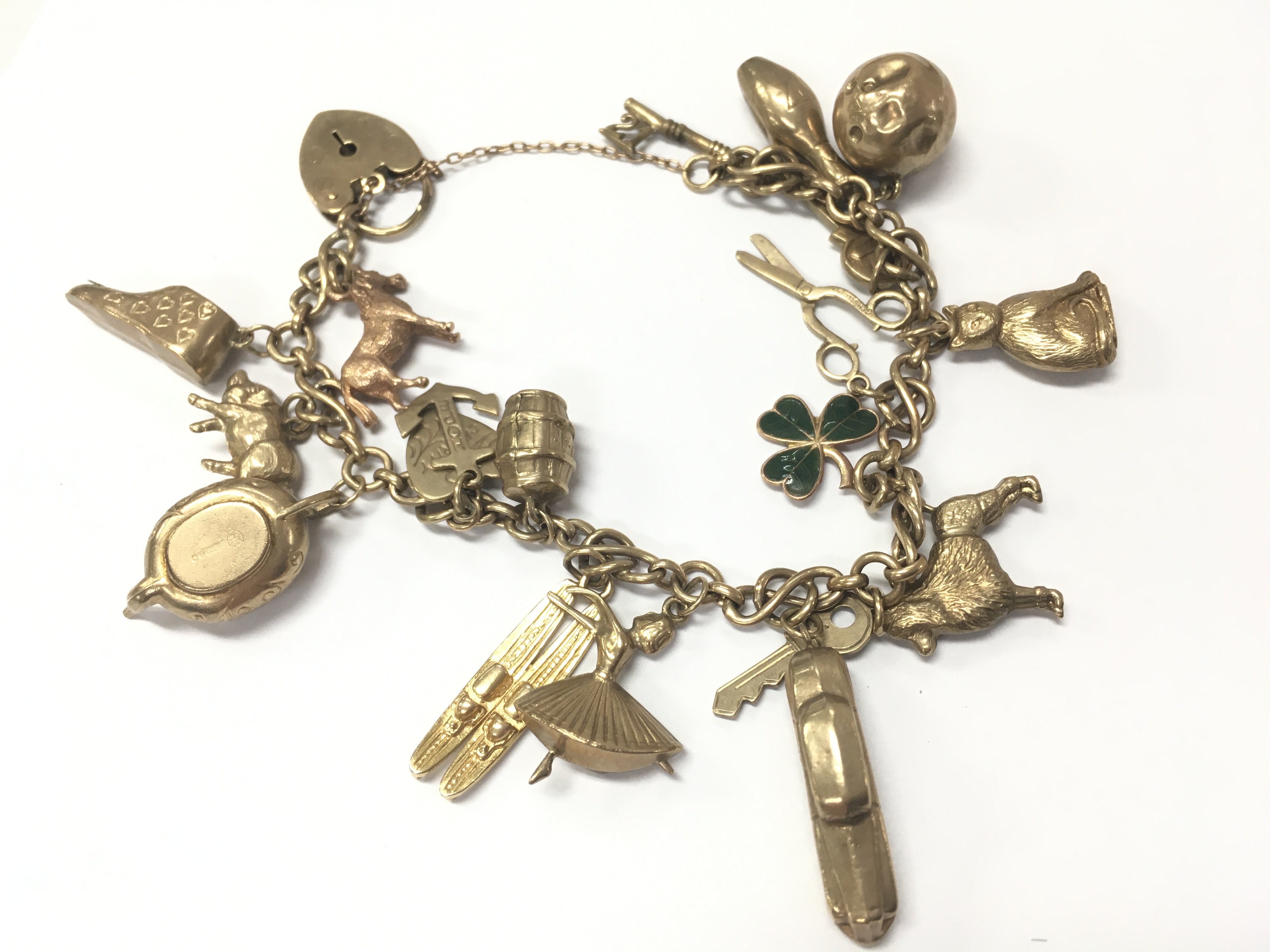 A 9 carat gold charm bracelet. 31.6g total weight. Postage category A