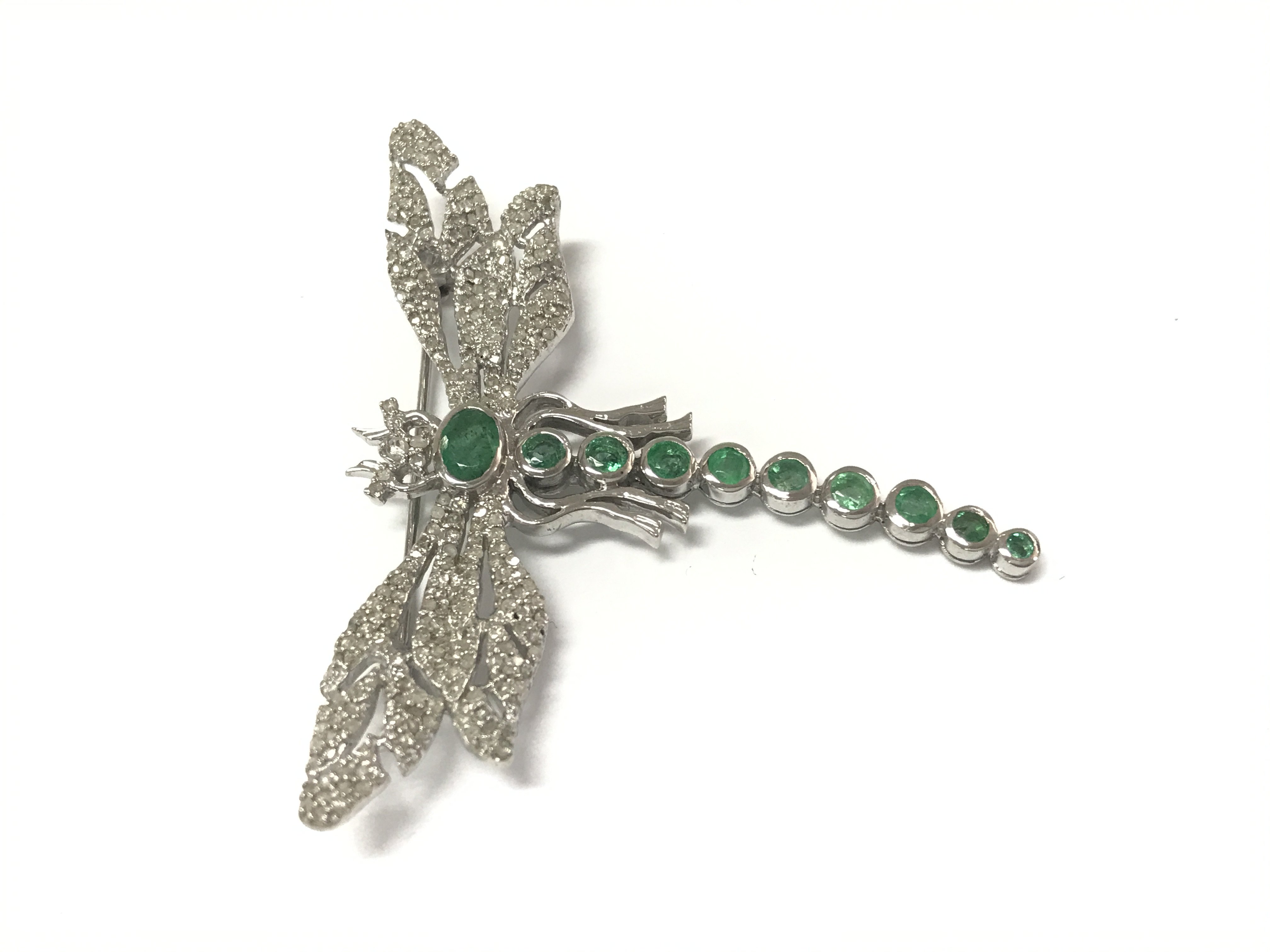 A silver dragonfly brooch / pendant set with emeralds and diamonds. Emeralds 1.34ct and diamonds 1.18ct approximately.
