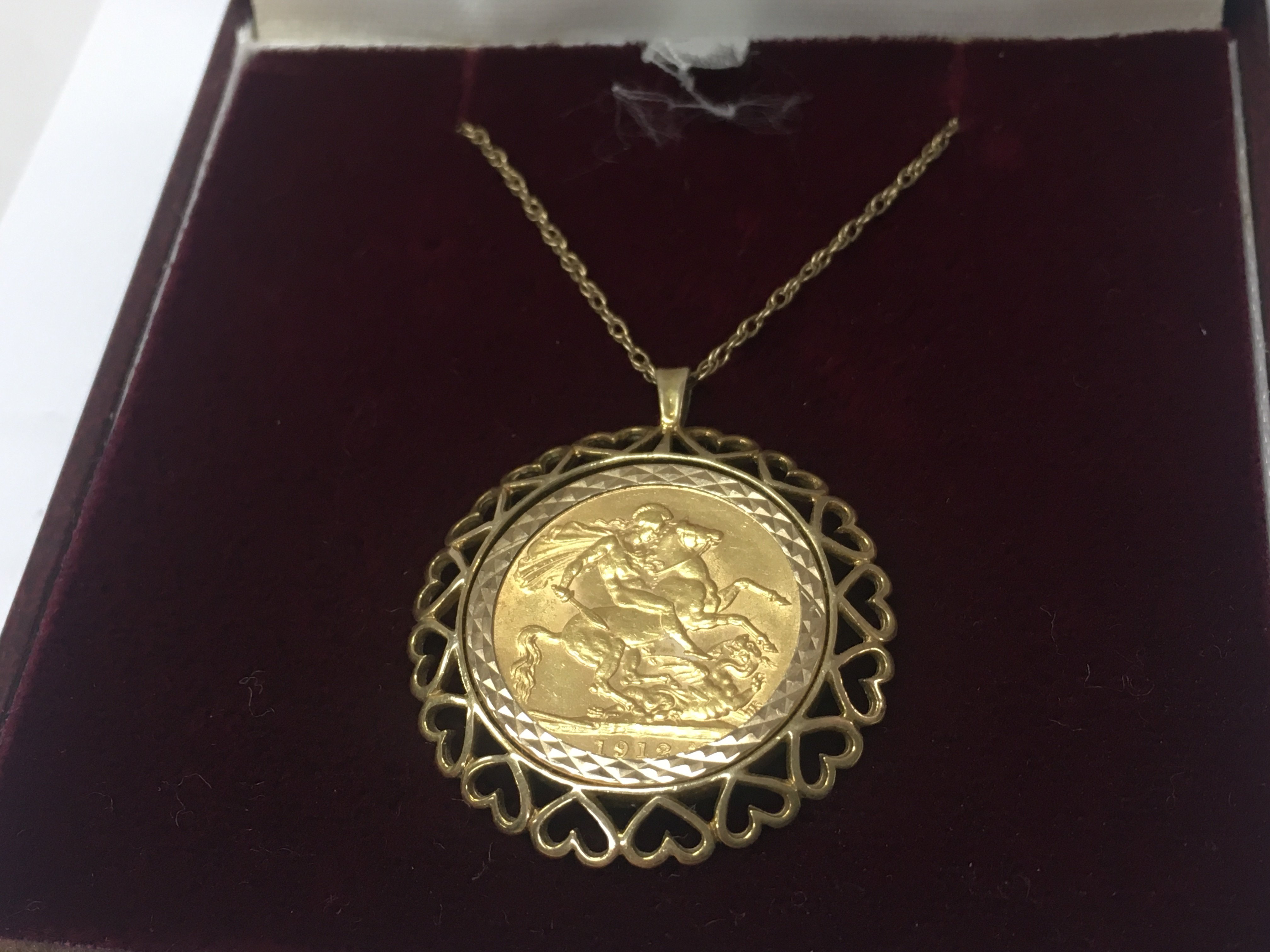 A 1912 full sovereign and chain, 14g total weight. Postage category A