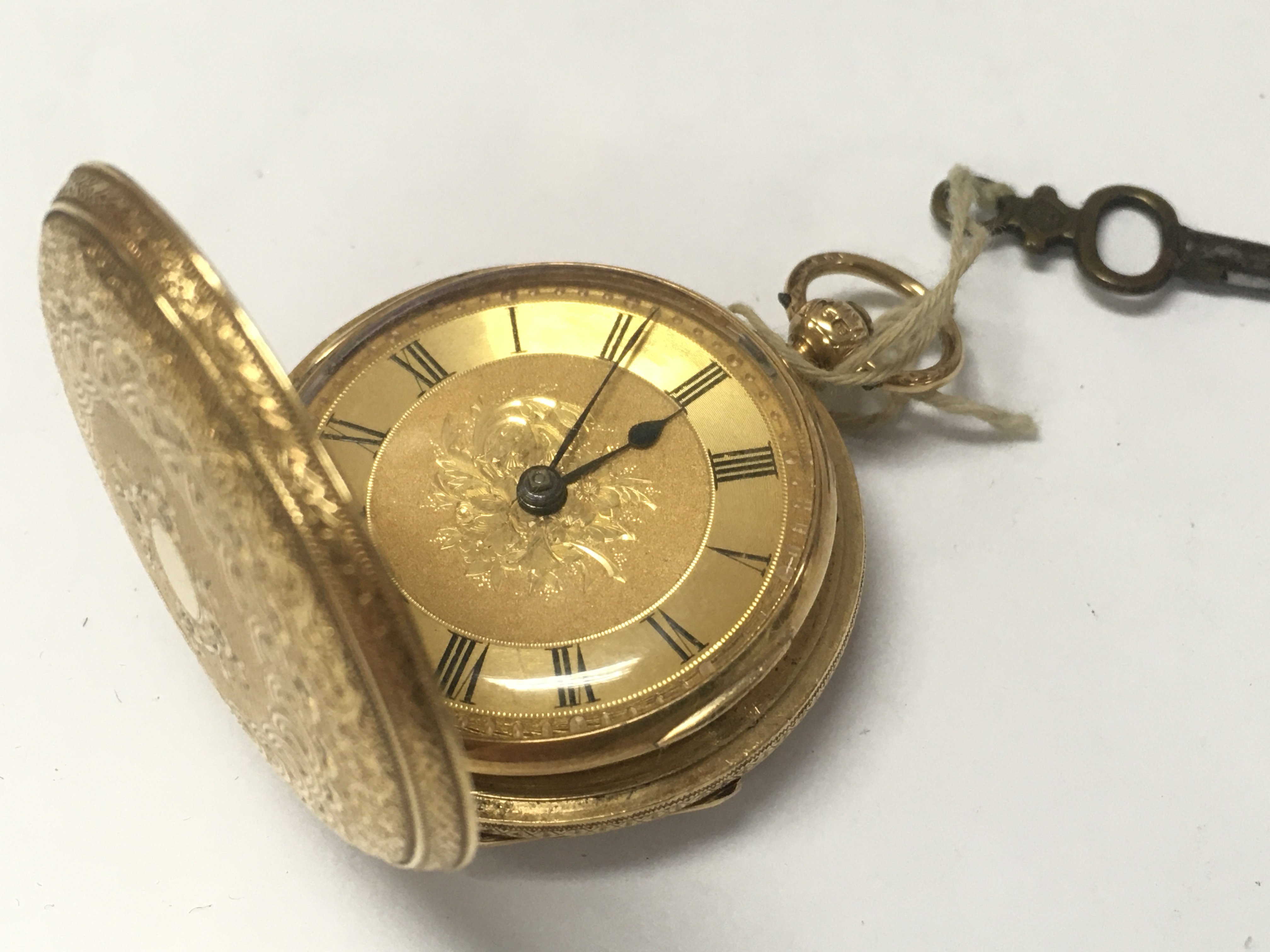 An 18ct gold fob watch , with key . Postage category A
