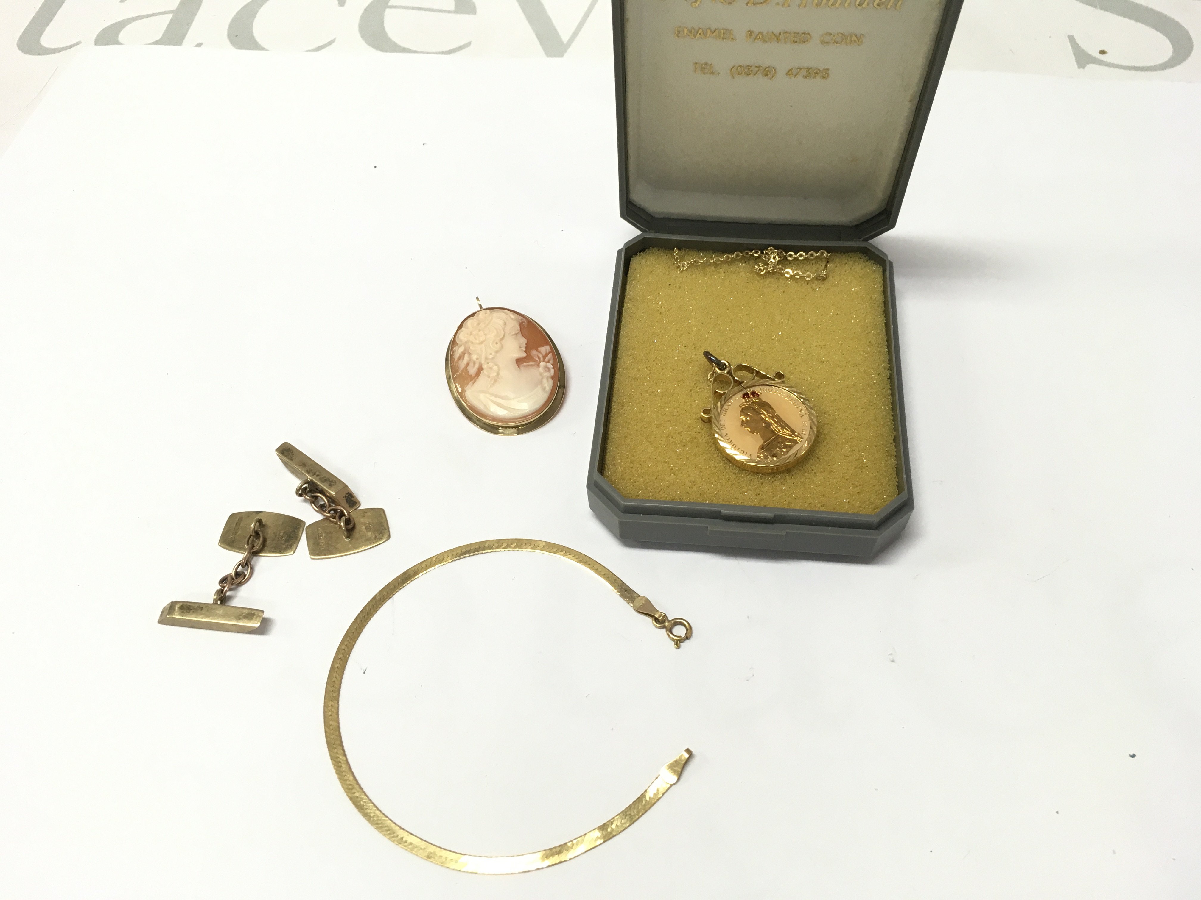 A collection of 9ct gold items including bracelets cufflinks brooch and a 9ct gold mount with enamel coin. Postage B