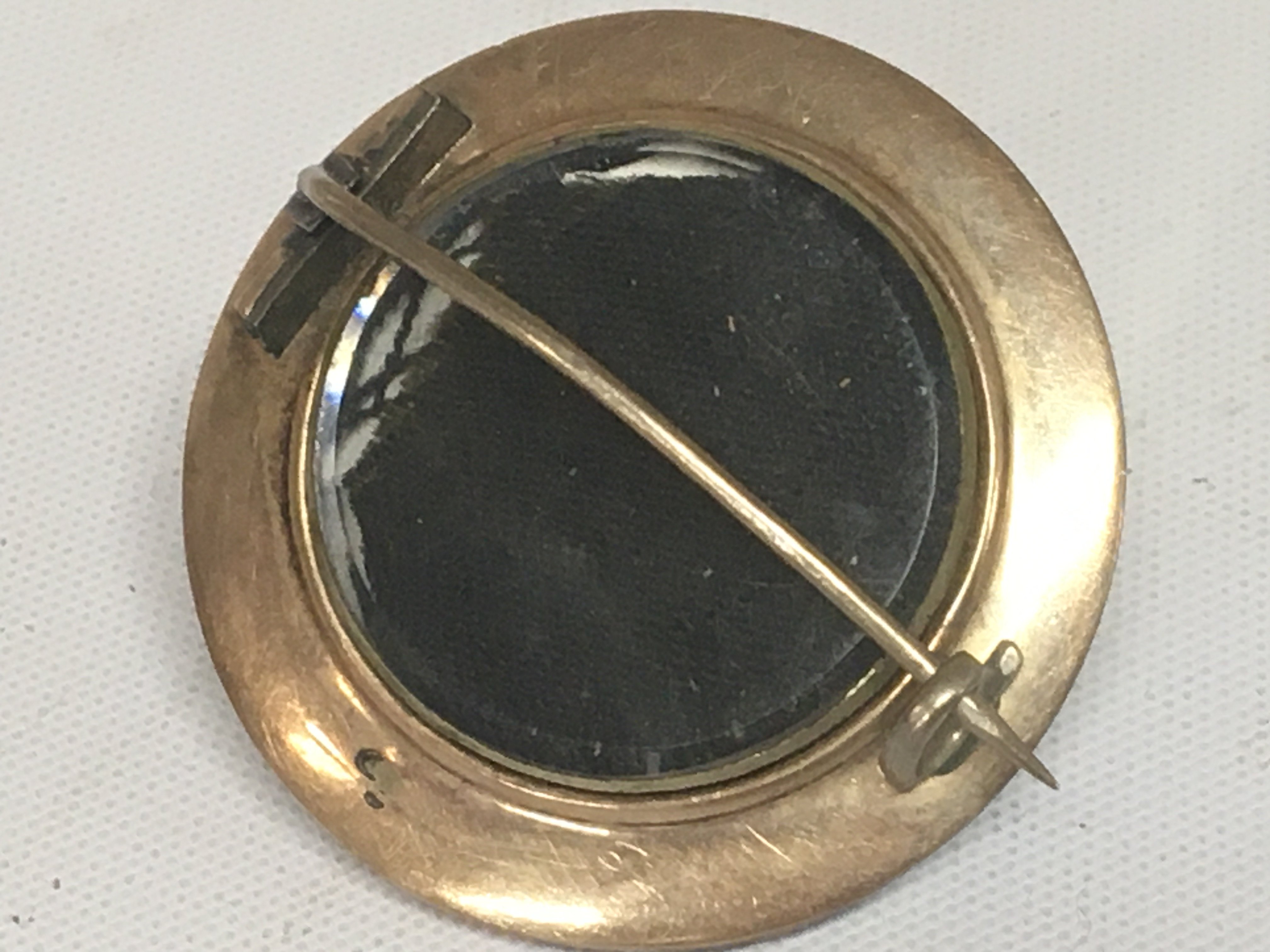 An Antique gold and pale blue enamel mourning brooch of oval shape with a central seed pearl. Unmarked.