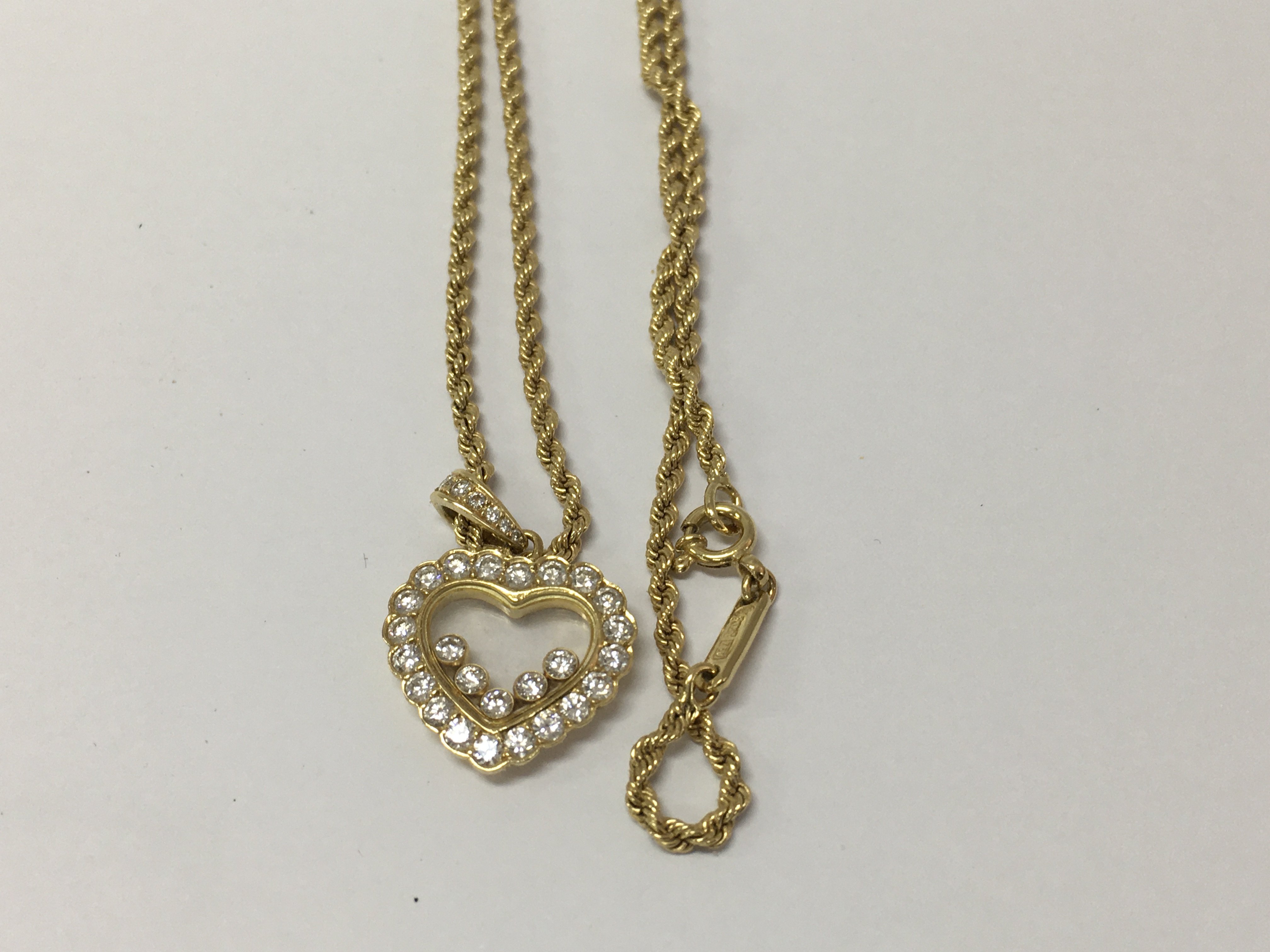 A Chopard Happy diamond 18ct yellow gold heart pendant, the frame inset with five floating round cut brilliant diamonds with attached rope chain .fitted in original box .