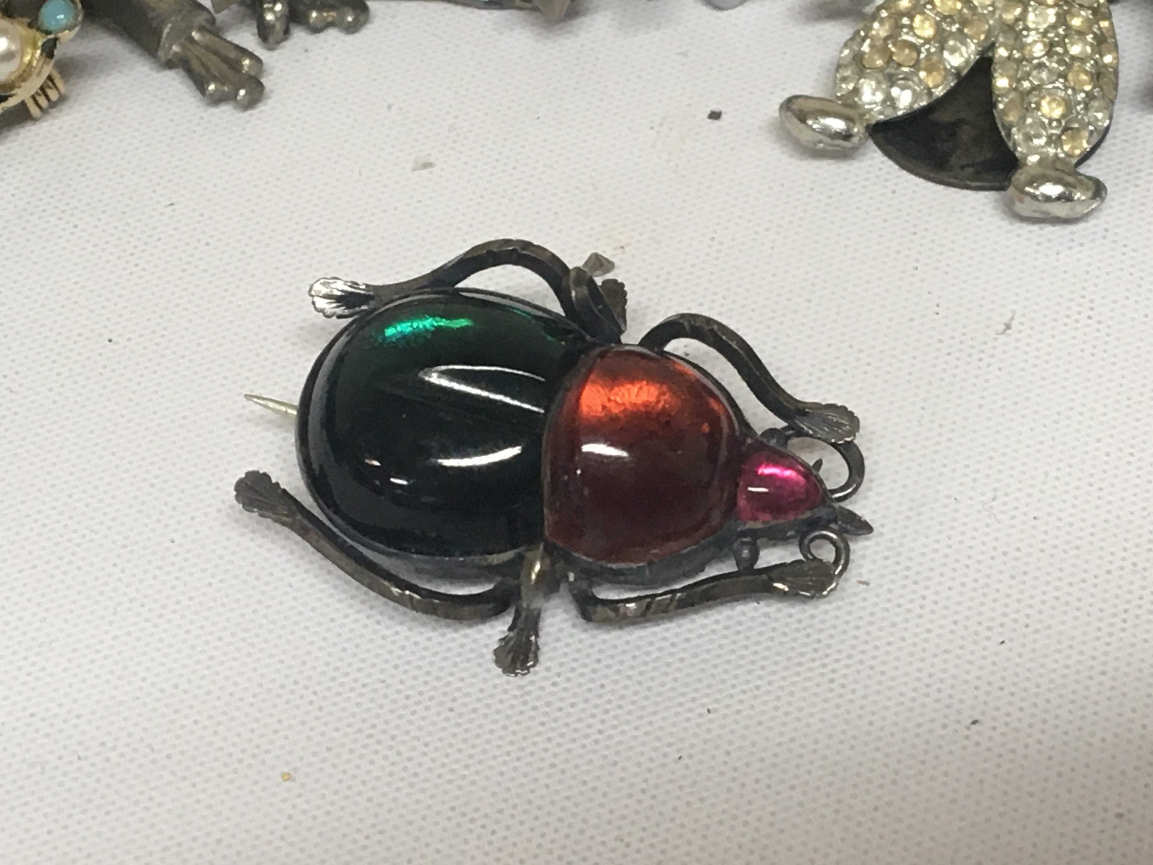 A collection of costume jewellery including a Beatle brooch and other brooches rings and oddments.- NO RESERVE