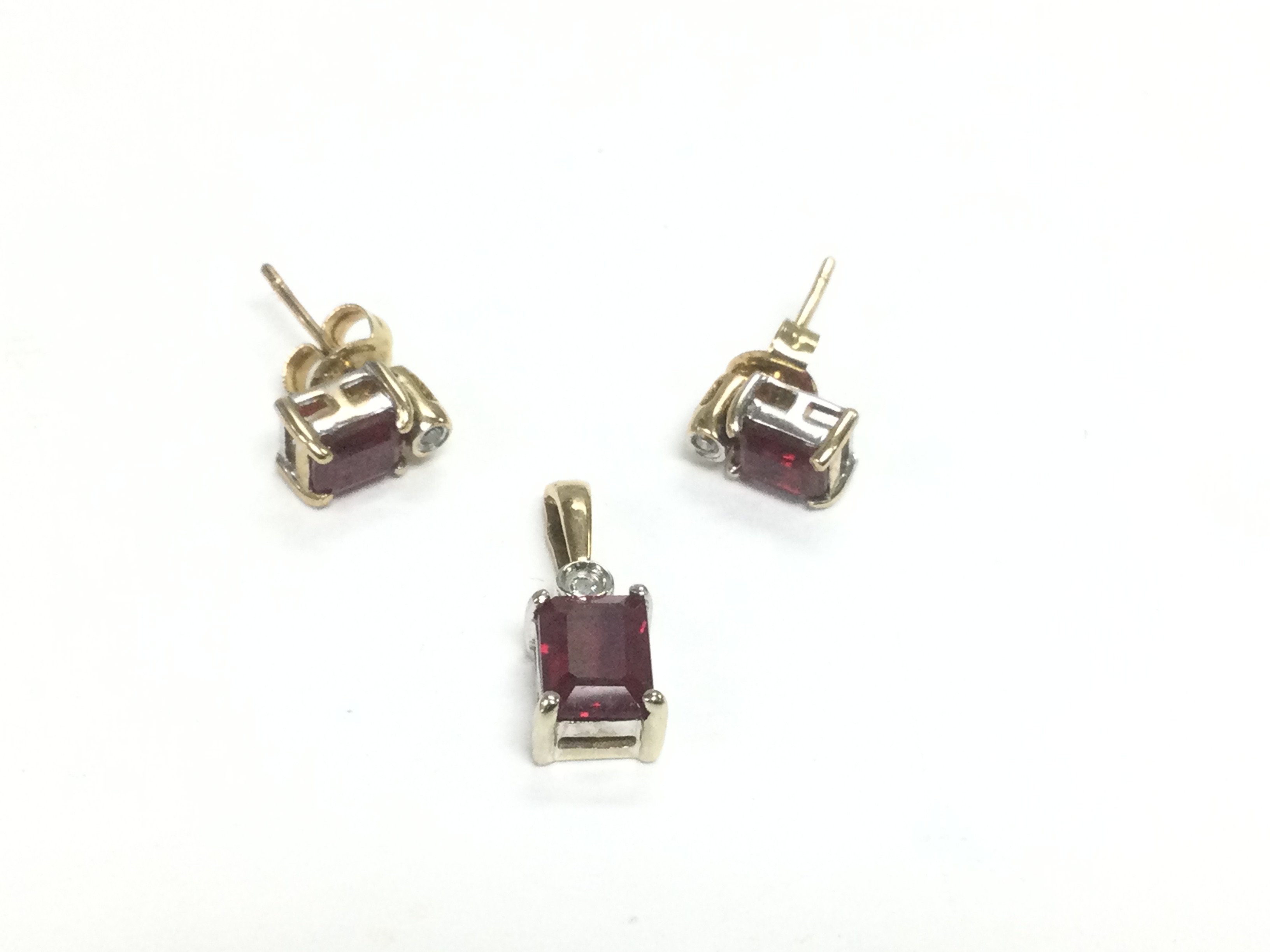 A 9ct gold, synthetic ruby and diamond jewellery suite comprising a pendant and pair of earrings, total approx weight 2.5g. Shipping category A.