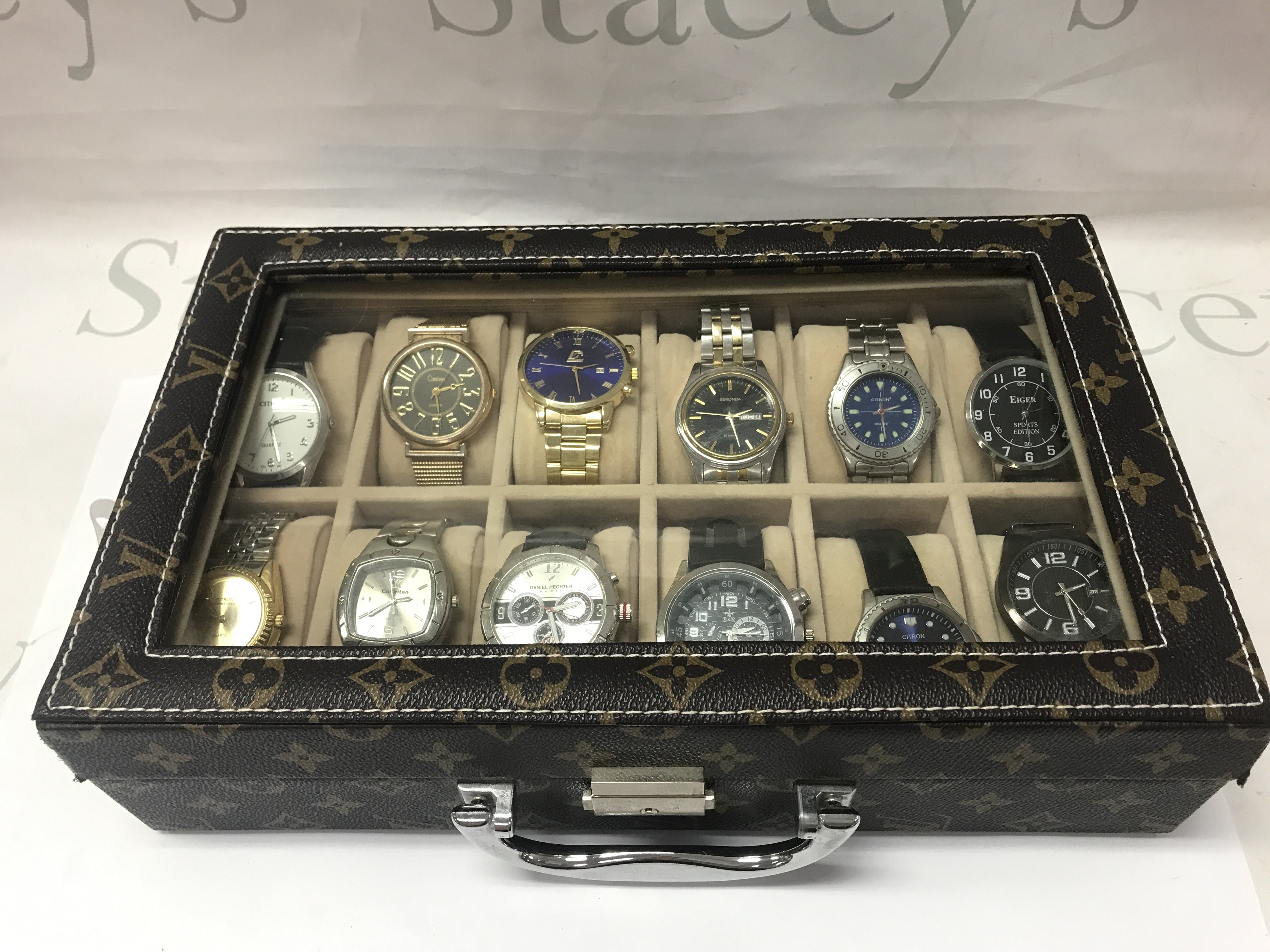 Twelve Gents watches including Citron, Sekonda etc all seen working. With Louis Vuitton style display case. Postage category B