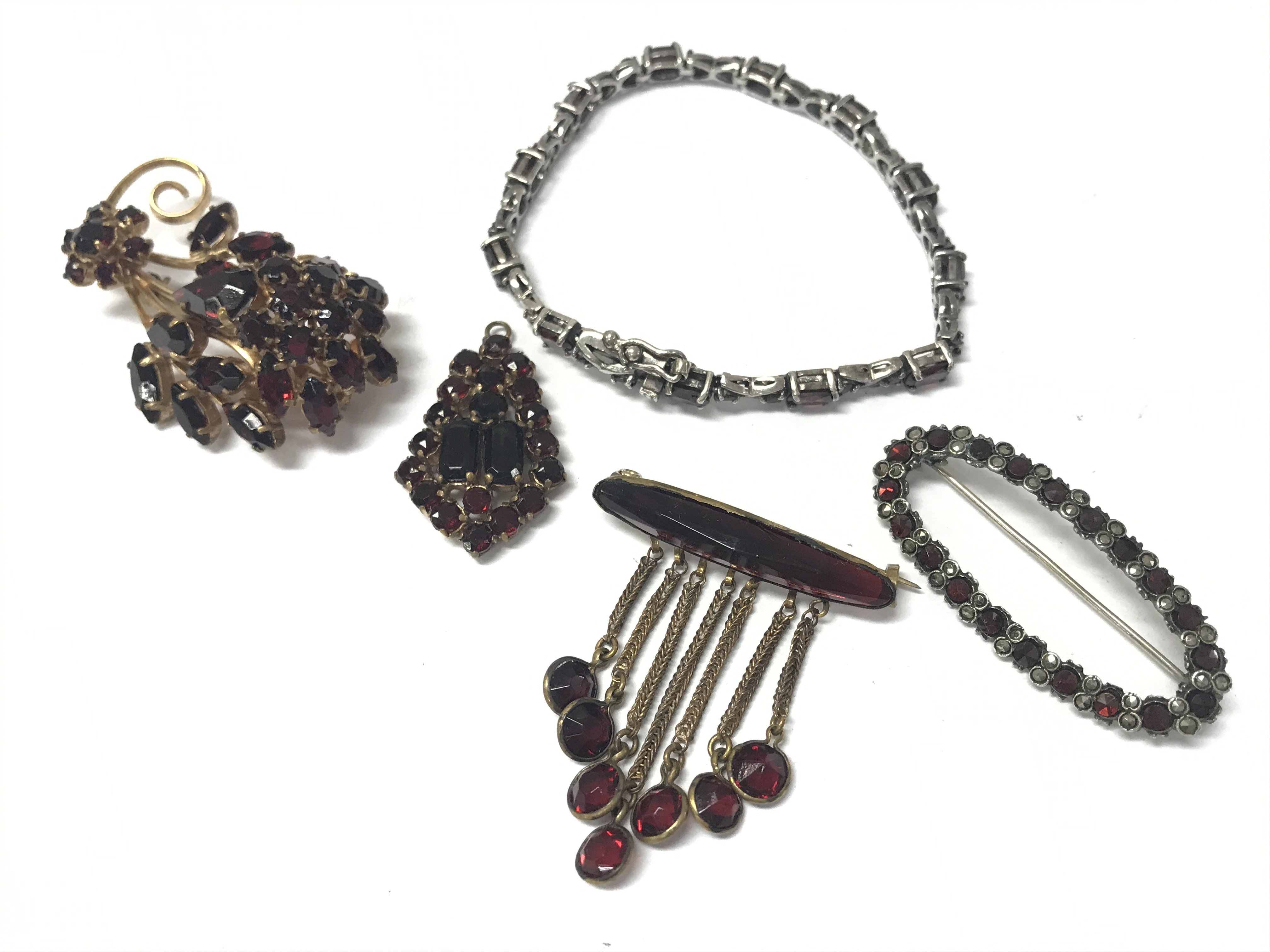 A silver garnet bracelet and brooch, plus two garnet brooches and a pendant . Postage category A