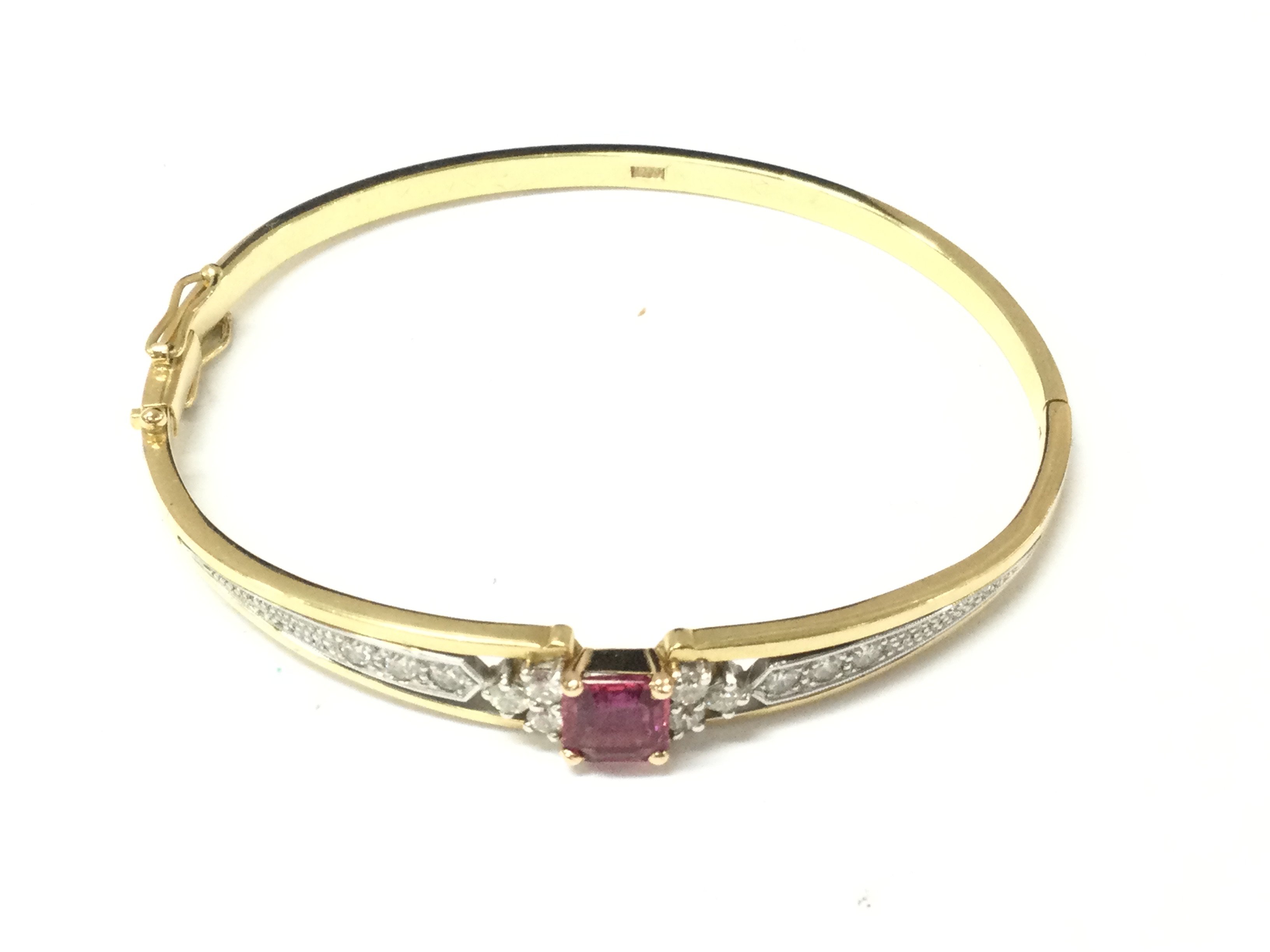 An 18ct gold ruby and diamond bracelet. 19.01g and approximately 6.5cm diameter. Postage B