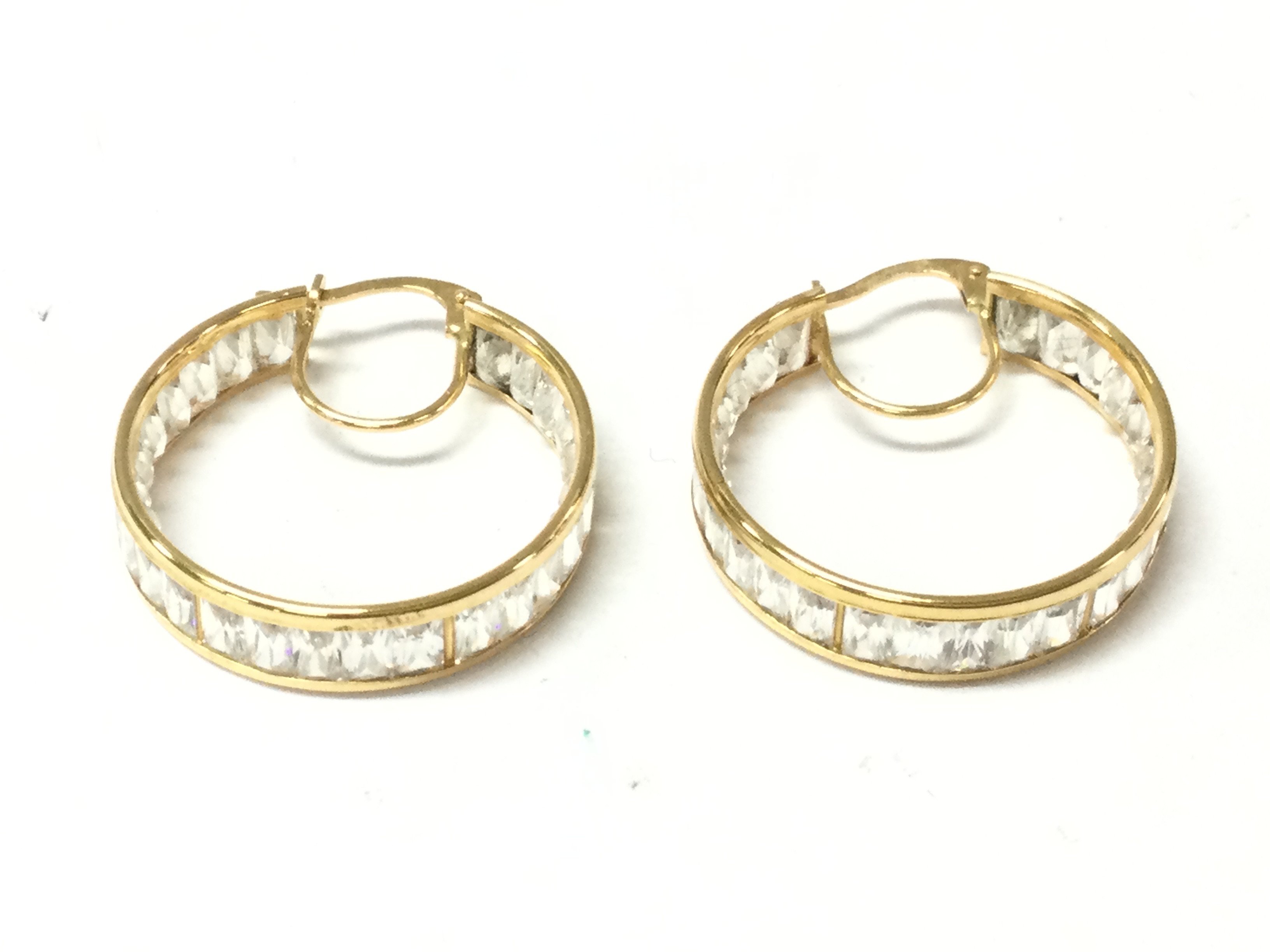 An unhallmarked high grade gold pair of hoop earrings set with white stones. 6.02g Postage B