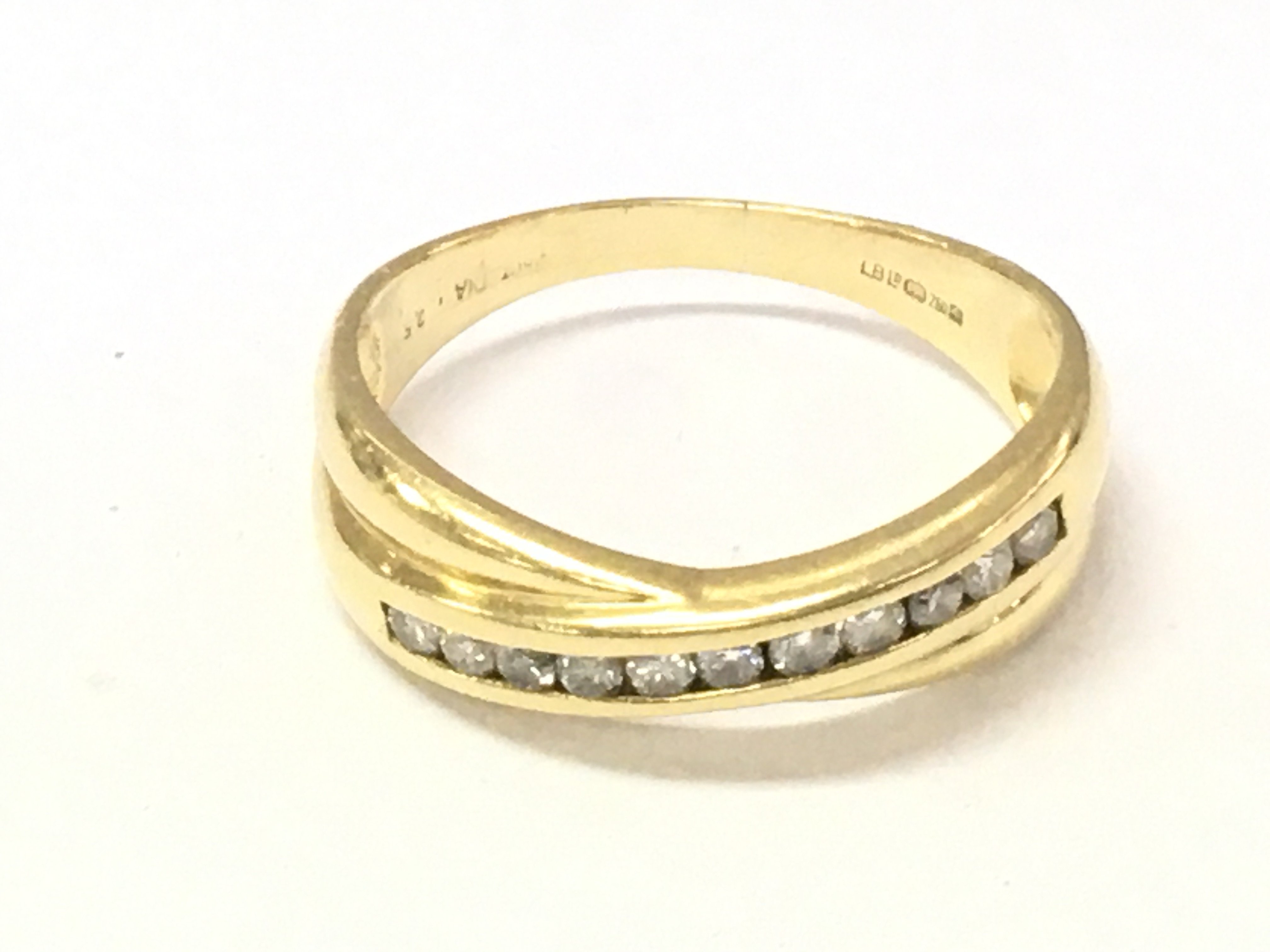 An 18ct gold diamond cross over band ring. Approx 1/4ct size T and 4.44g.