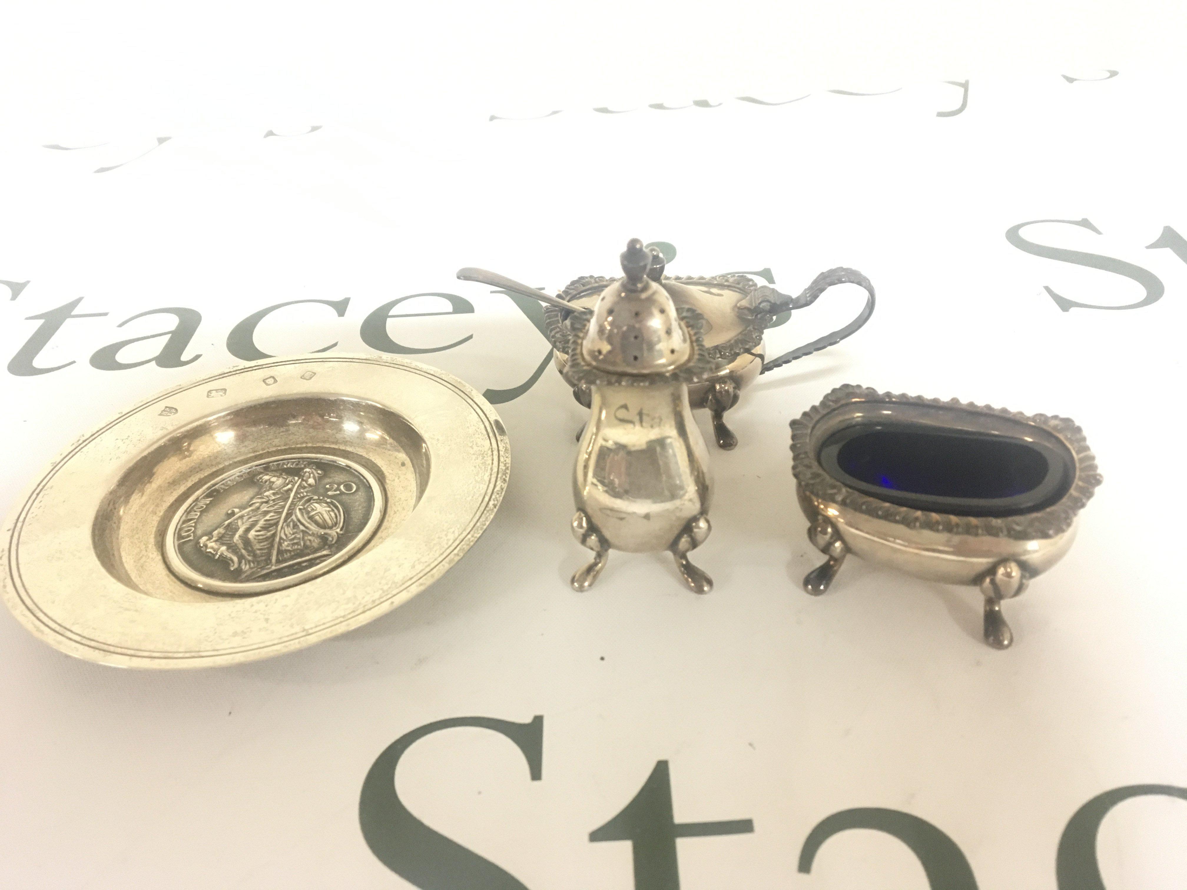 A silver dish London Assurance and a three piece silver condiment set.