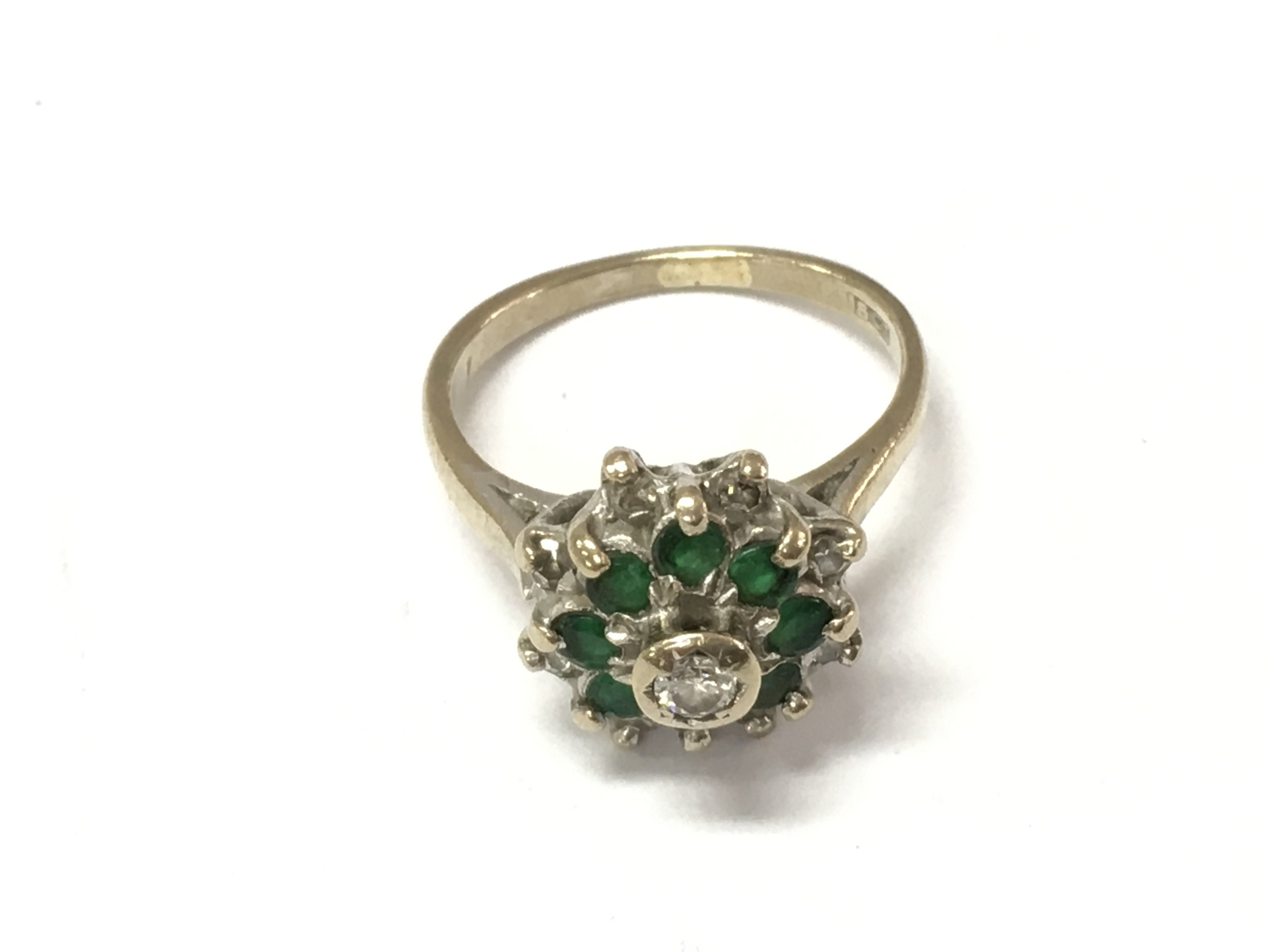 An 18ct gold diamond and emerald cluster ring. Size H 1/2 and 4.25g Postage A
