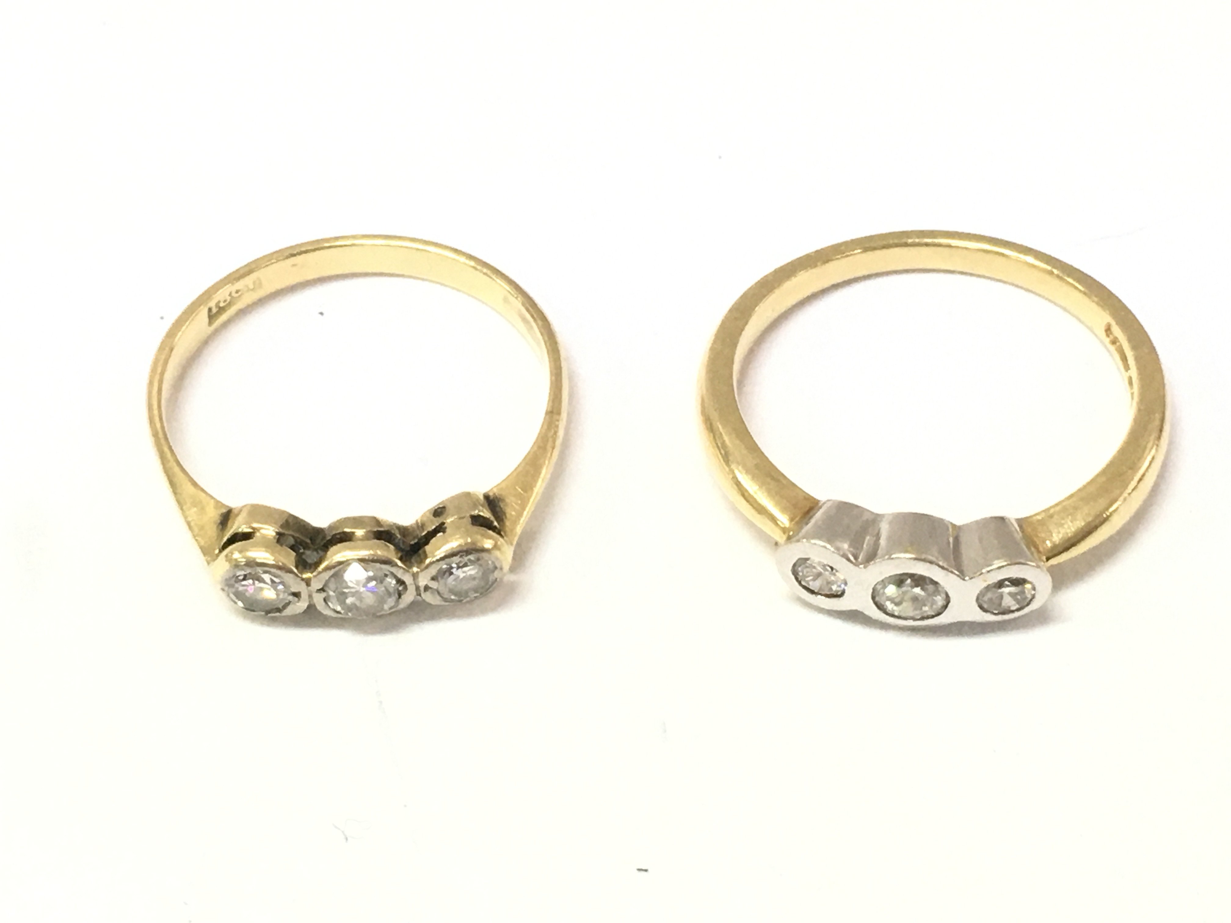 Two 18ct gold three stone diamond rings. Sizes N and O 6.3g Postage A