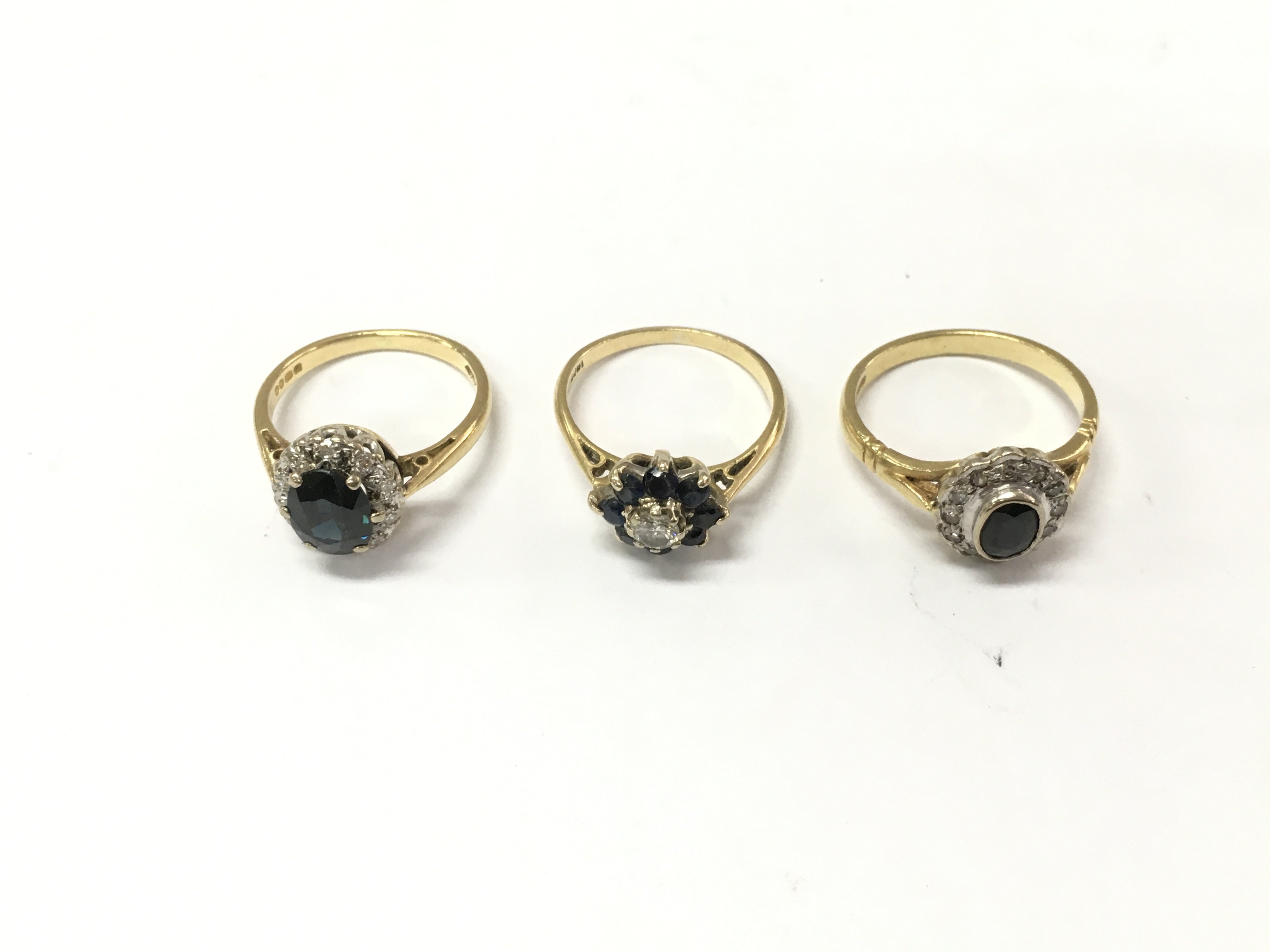 Three 18ct gold diamond and sapphire cluster rings. Size K 1/2 and M. 10.34g Postage A