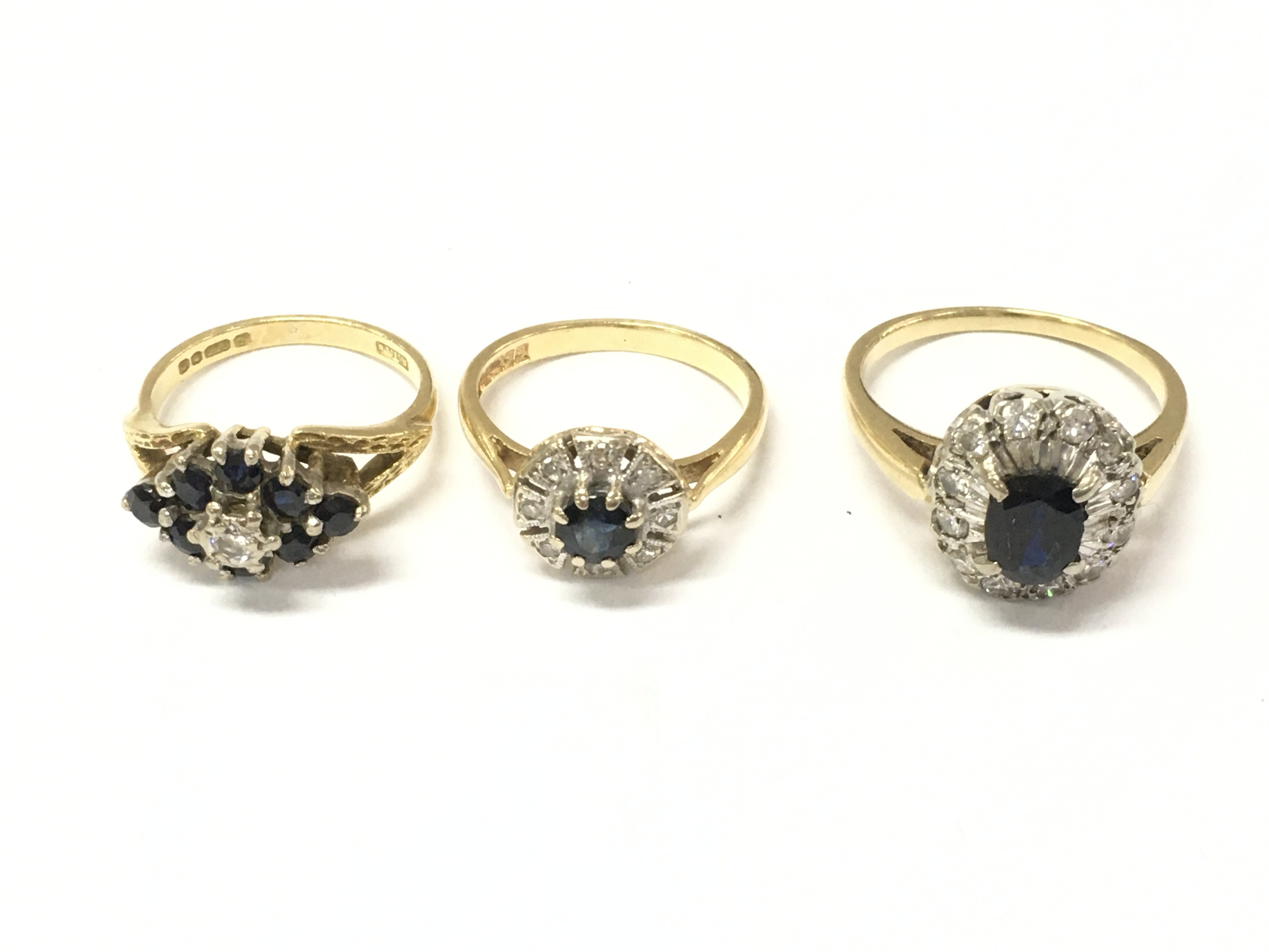 Three 18ct gold diamond and sapphire cluster rings. Size K 1/2 and M. 11.39g Postage A