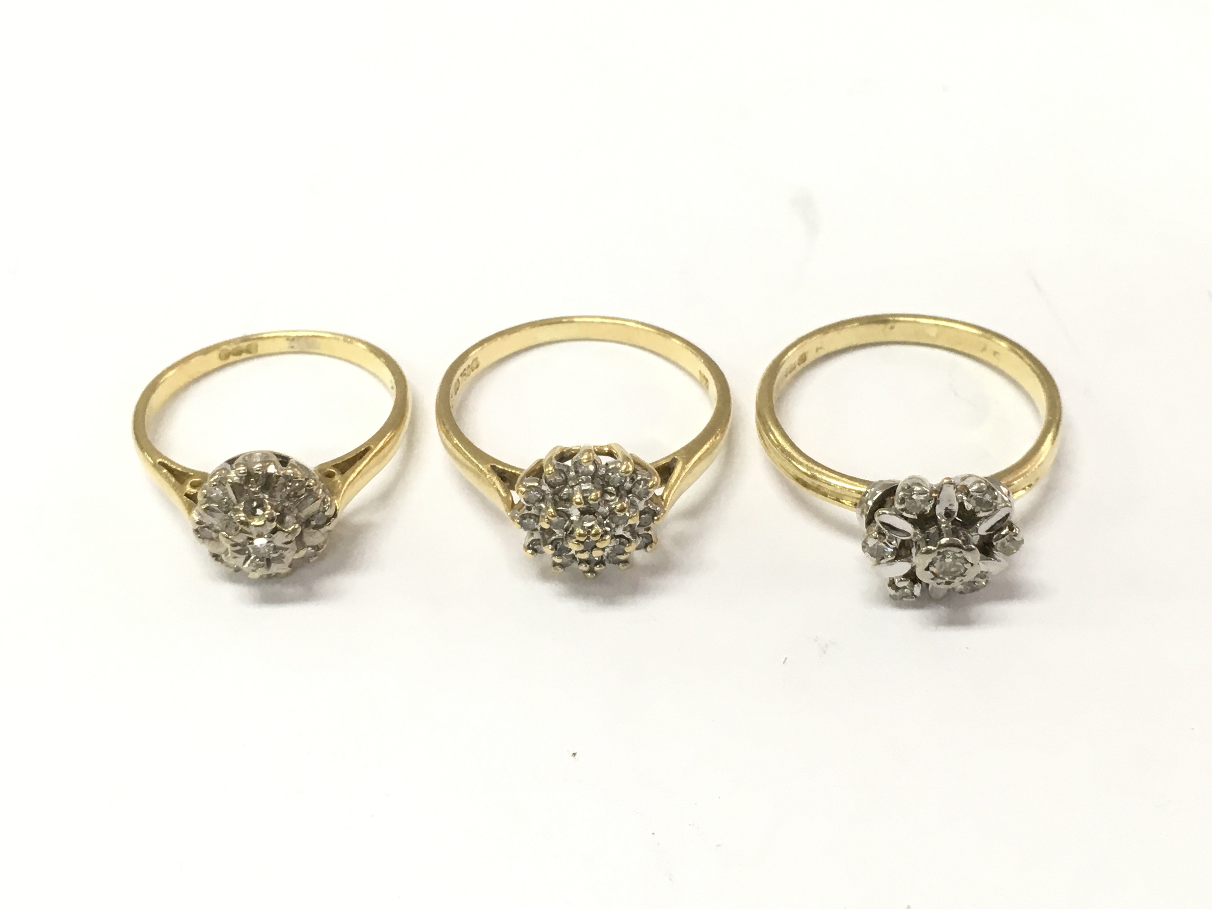 Three 18ct gold diamond and sapphire cluster rings. Size K 1/2 and M. 9.72 Postage A