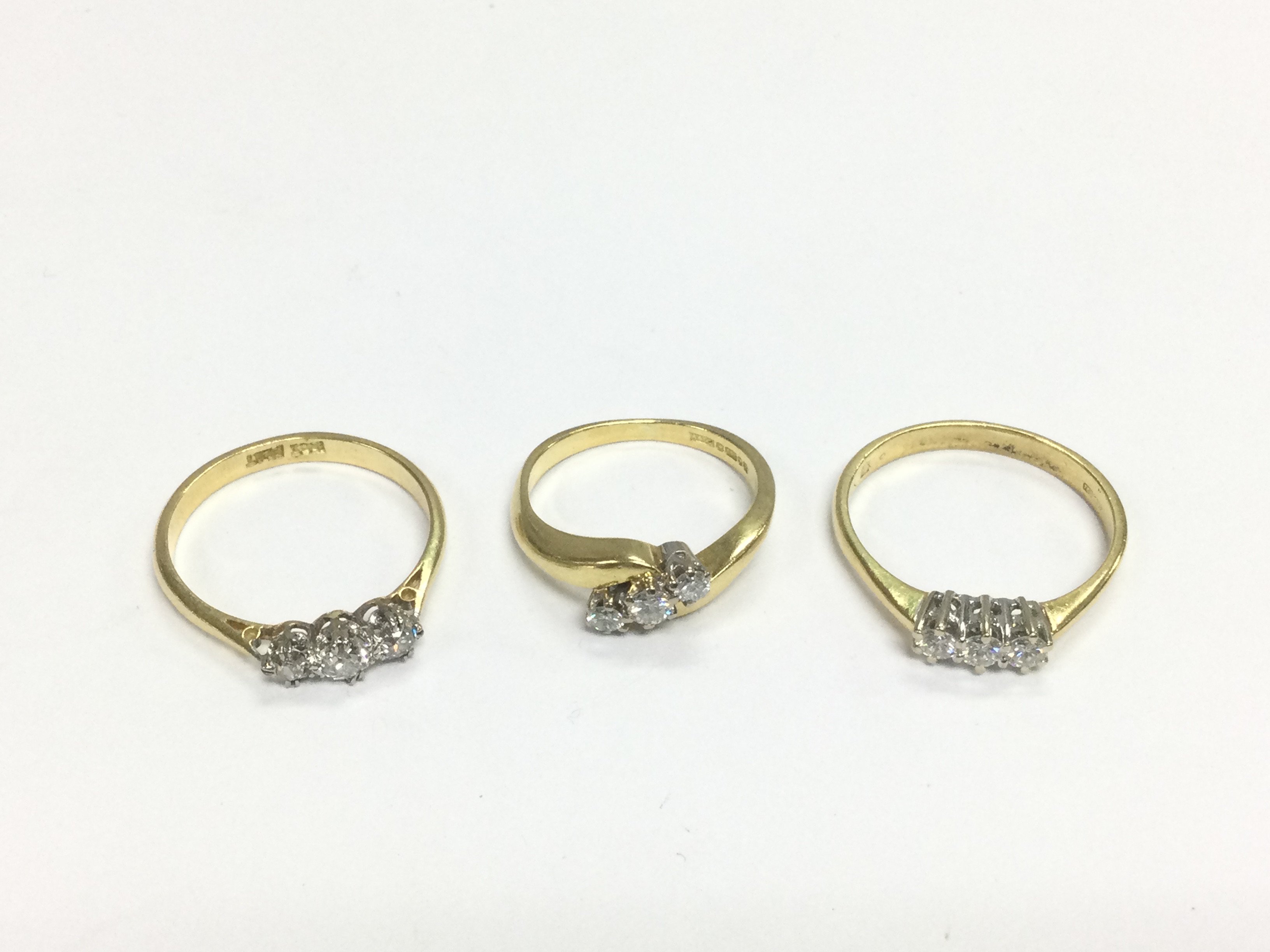Three 18ct gold three stone diamond rings, approx sizes I-J, O and P. Total approx 8.4g. Shipping category A.