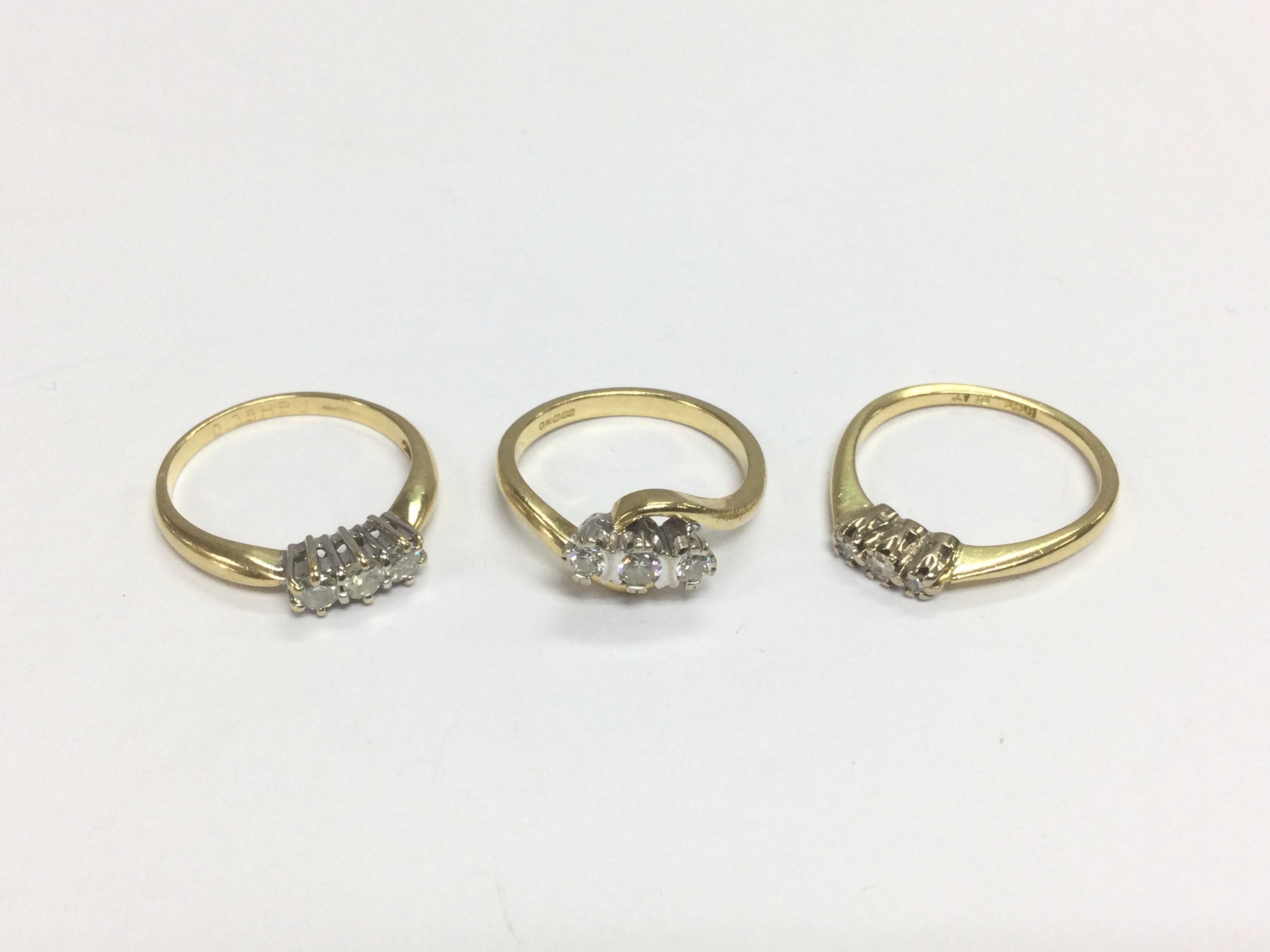 Three 18ct gold three stone diamond rings, approx sizes M, N and N-O. Total approx weight 9g. Shipping category A.