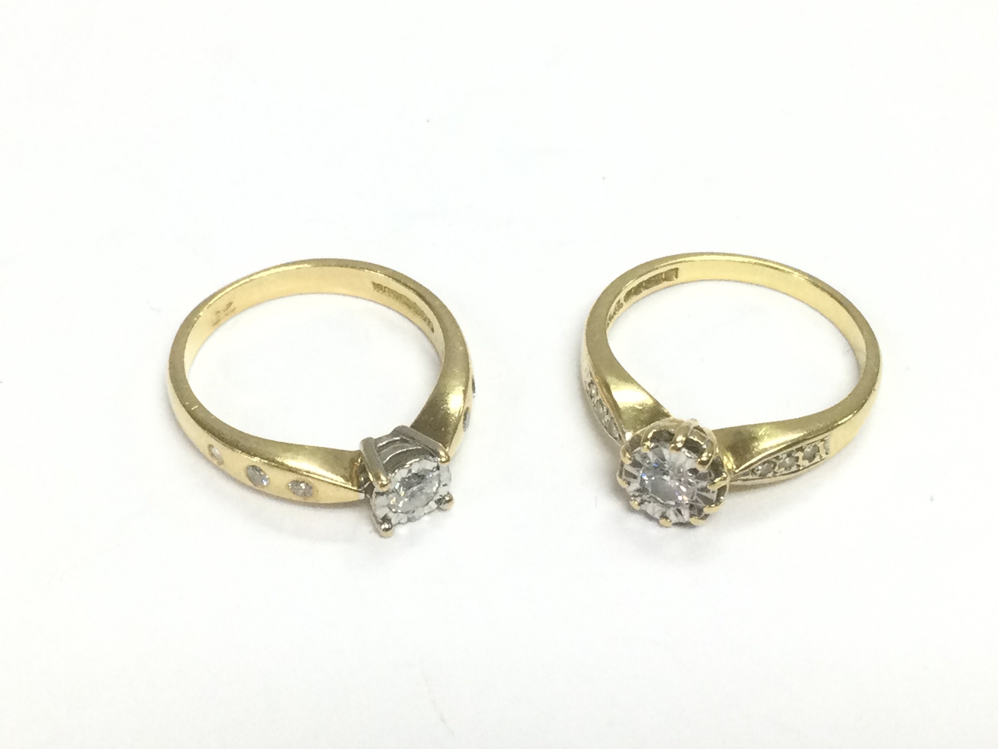 Two 18ct gold diamond solitaire rings set with diamond shoulders, approx sizes K-L and L. Approx total weight 7g. Shipping category A.