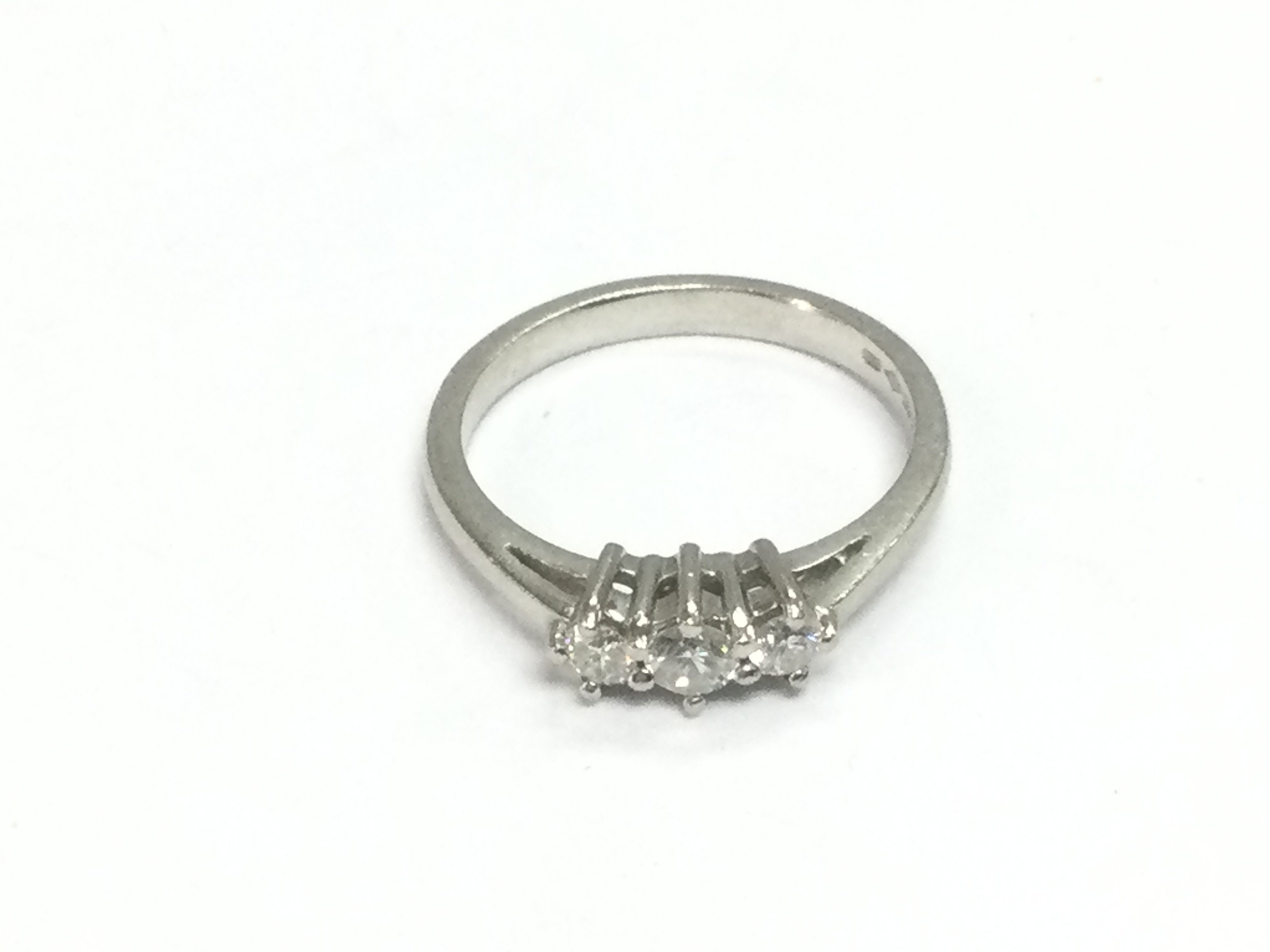 A platinum three stone diamond ring, approx size M and approx 4.6g. Shipping category A.