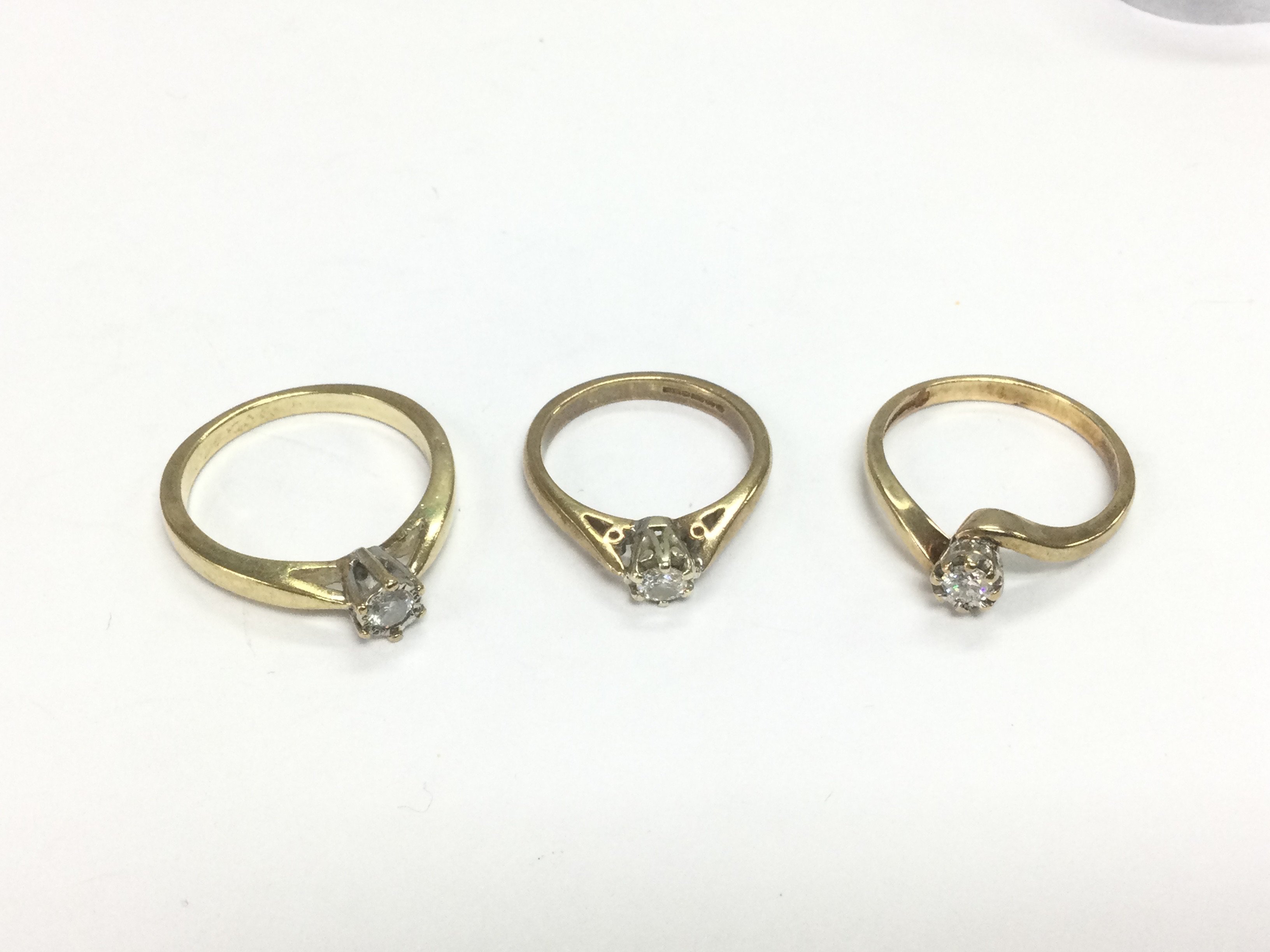 Three 9ct gold diamond solitaire rings, approx sizes P, J and N. Total approx 7.9g. Shipping category A.