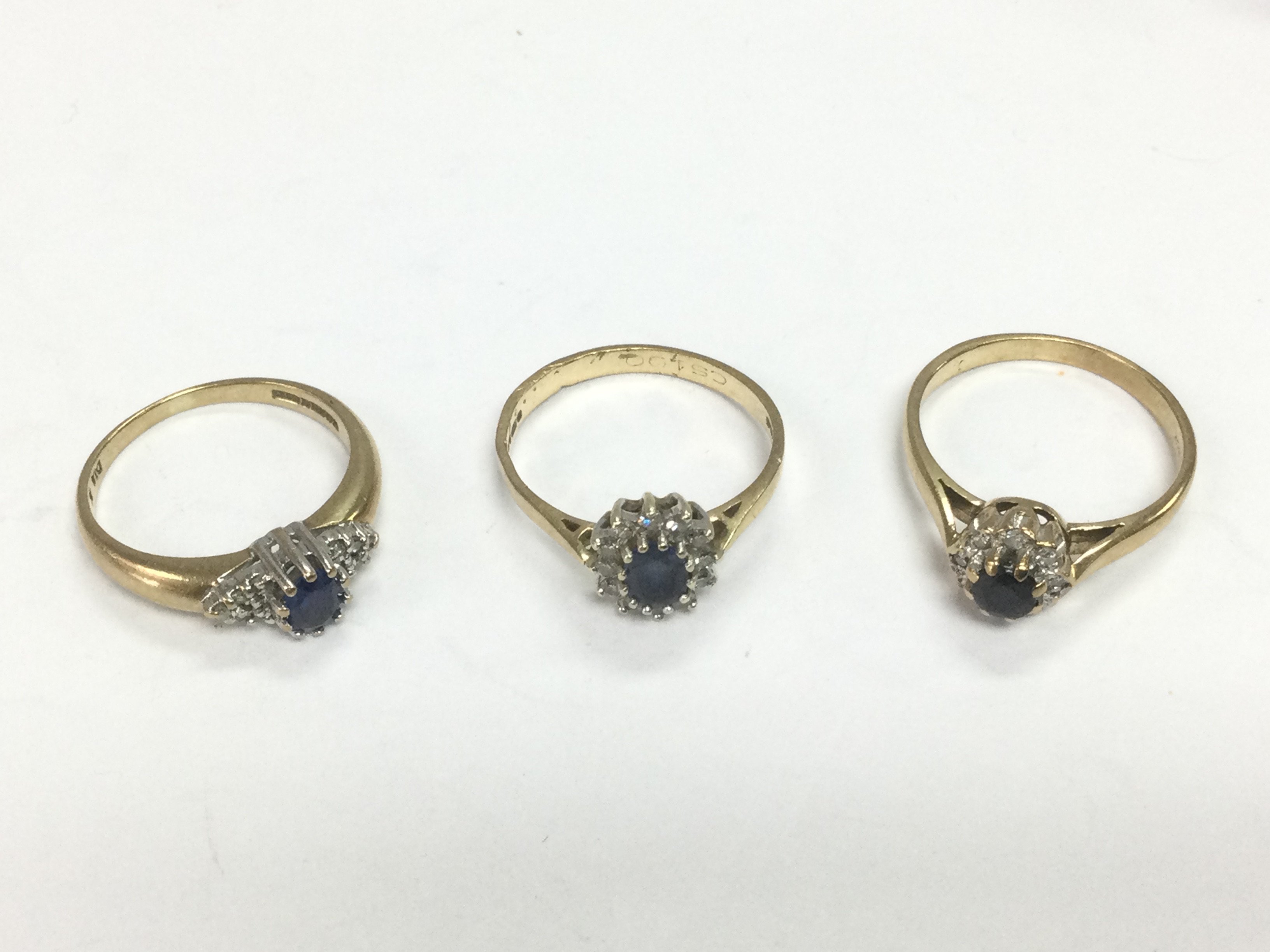 Three 9ct gold sapphire and diamond cluster rings, approx sizes K, M and L-M. Total approx 5.8g. Shipping category A.