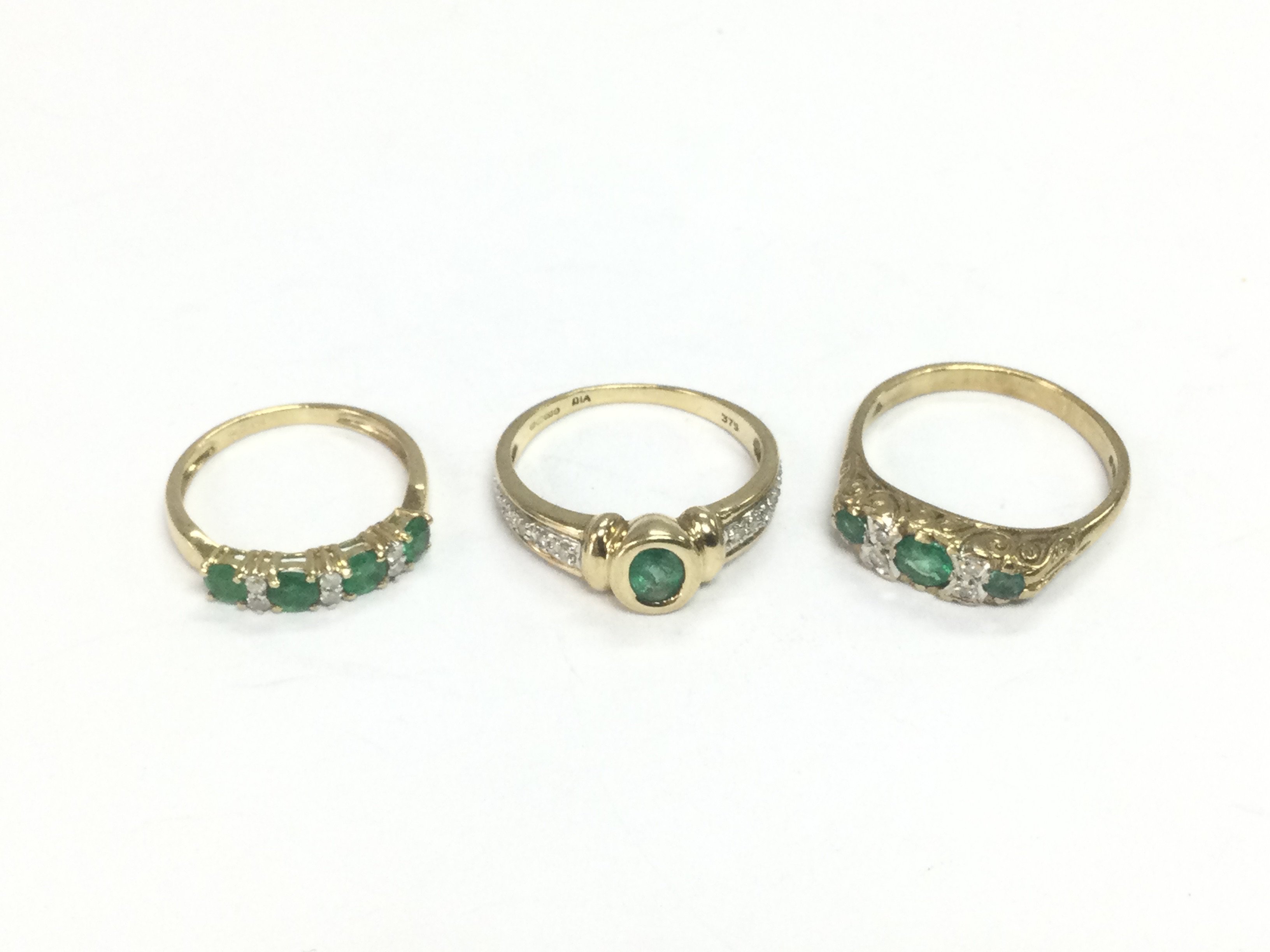 Three 9ct gold rings set with diamonds and emeralds, approx sizes J, N and O. Total approx 6.3g. Shipping category A.