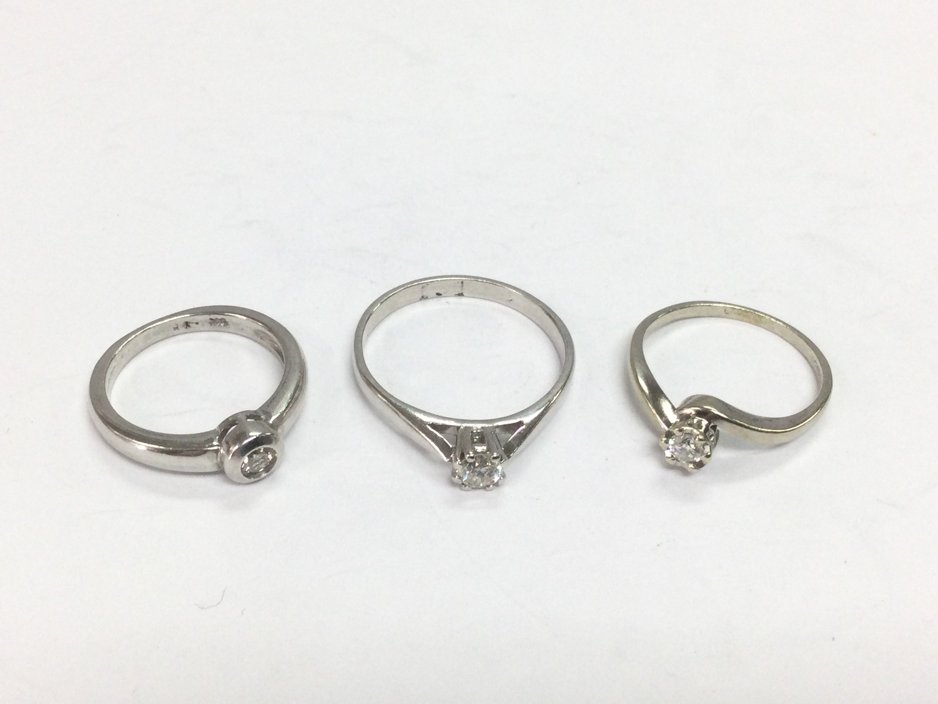 Three 9ct white gold diamond solitaire rings, approx sizes J, Q and K. Total approx 7.4g. Shipping category A.