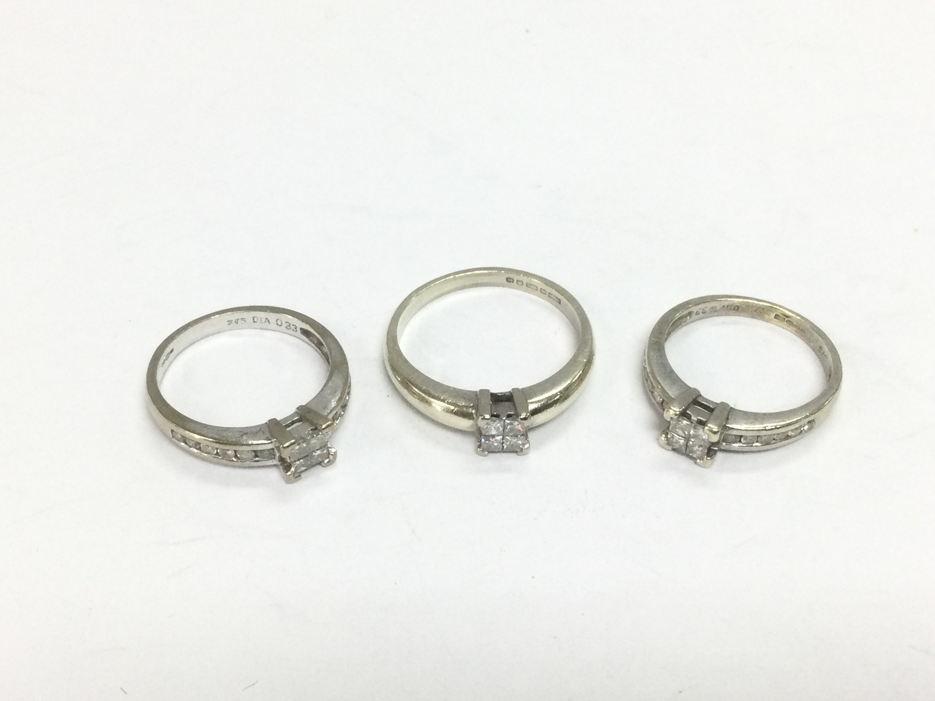 Three 9ct white gold princess cut diamond solitaire rings, approx sizes I, J and N. Total approx 7.6g. Shipping category A.