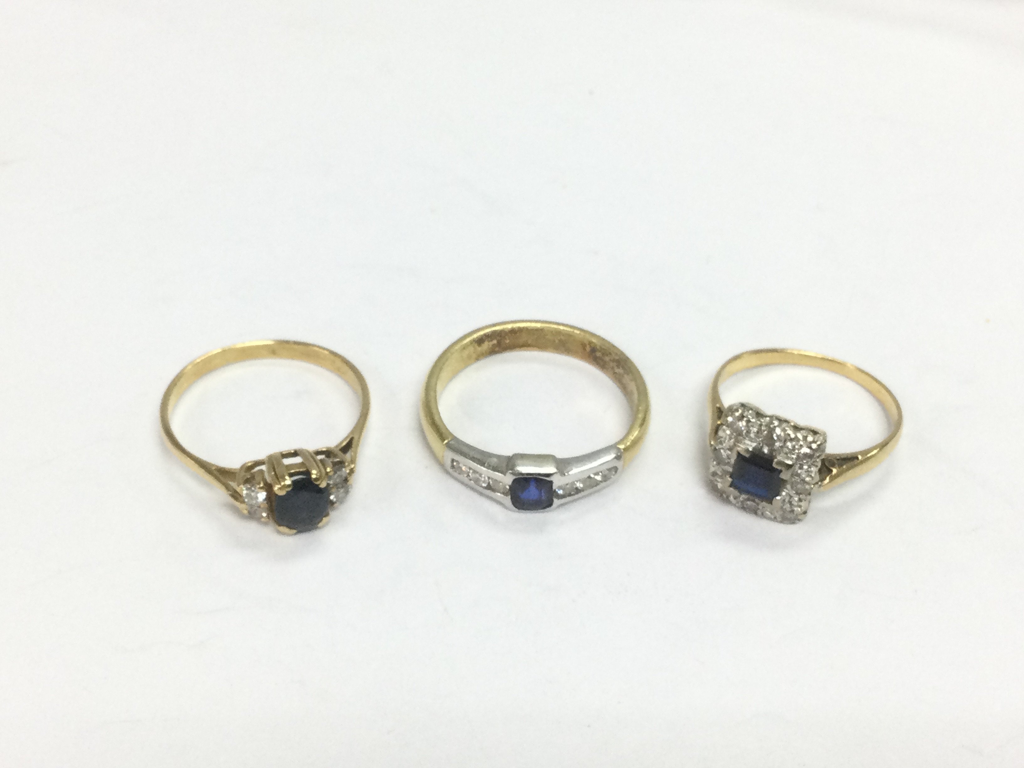 Three unmarked gold rings set with diamonds and sapphires, approx sizes N, P and L. Total approx 9.7g. Shipping category A.