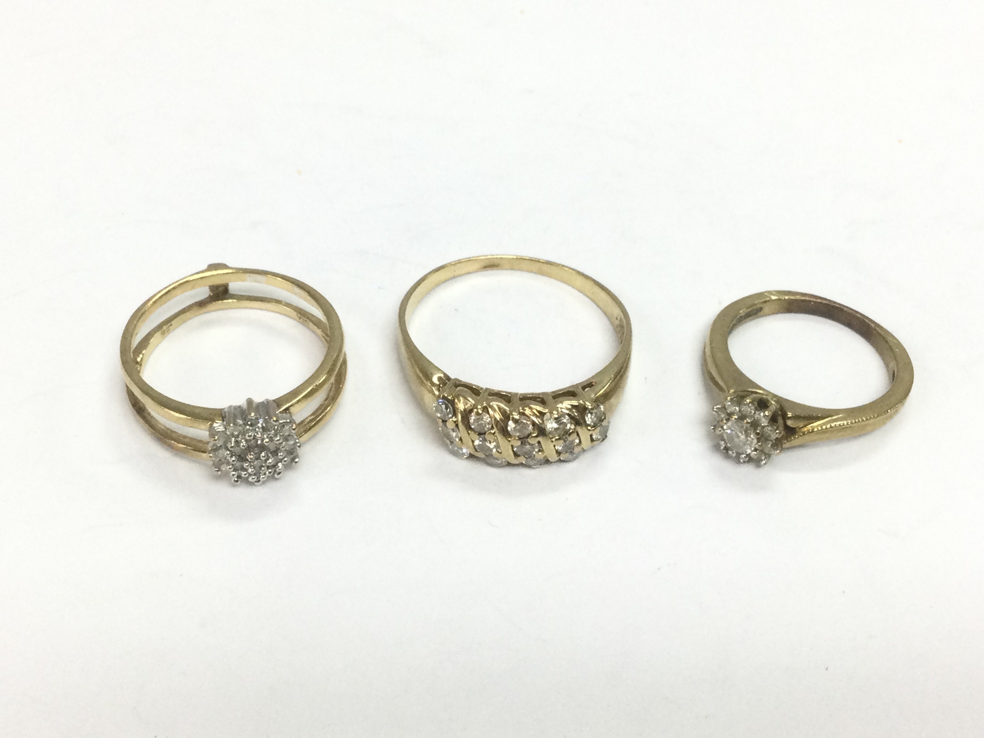 Three unmarked gold diamond cluster rings, approx sizes H, N and T.Total approx 8.3g. Shipping category A.