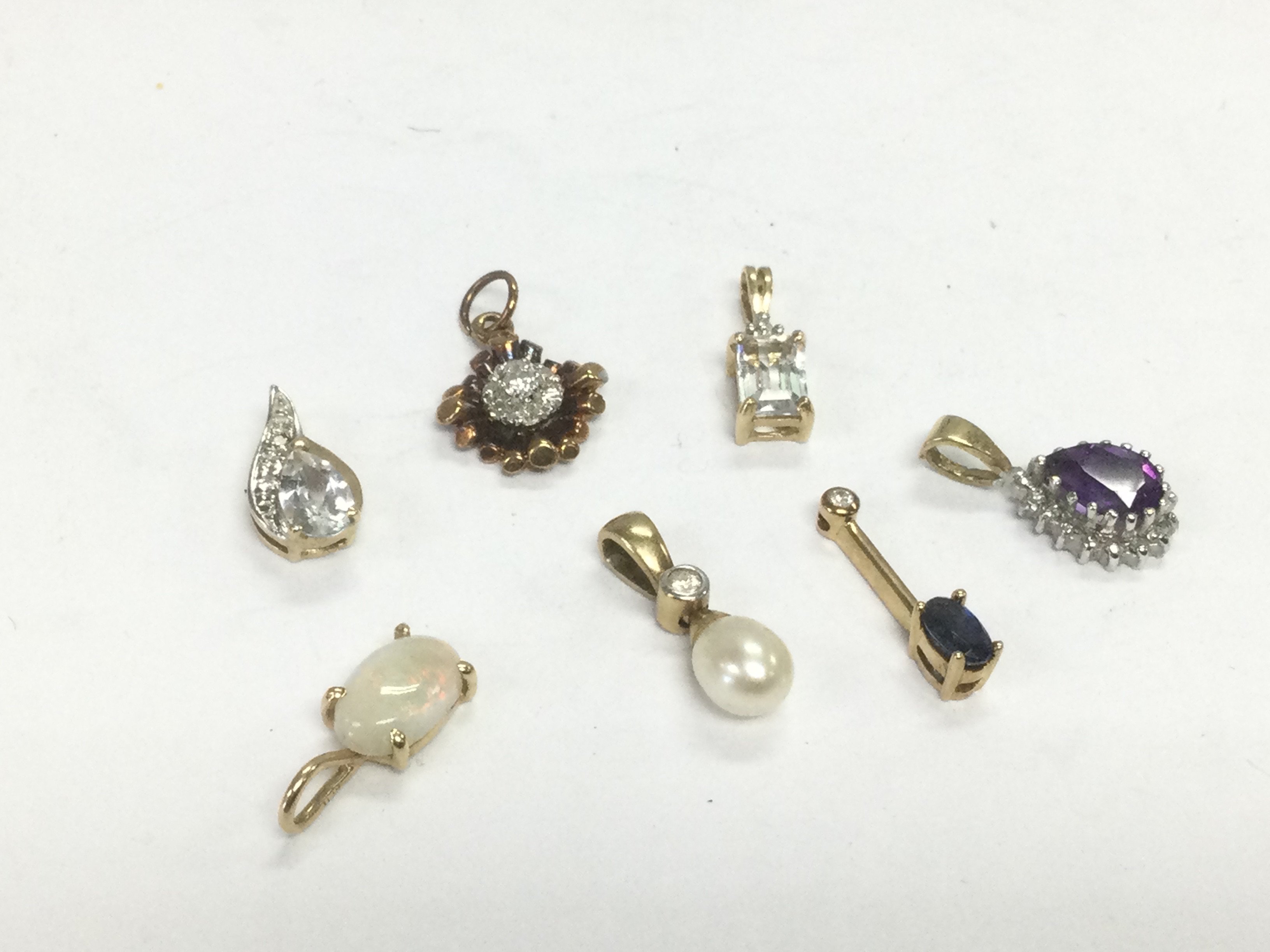 Seven 9ct gold pendants set with stones, total approx 4.4g. Shipping category A.