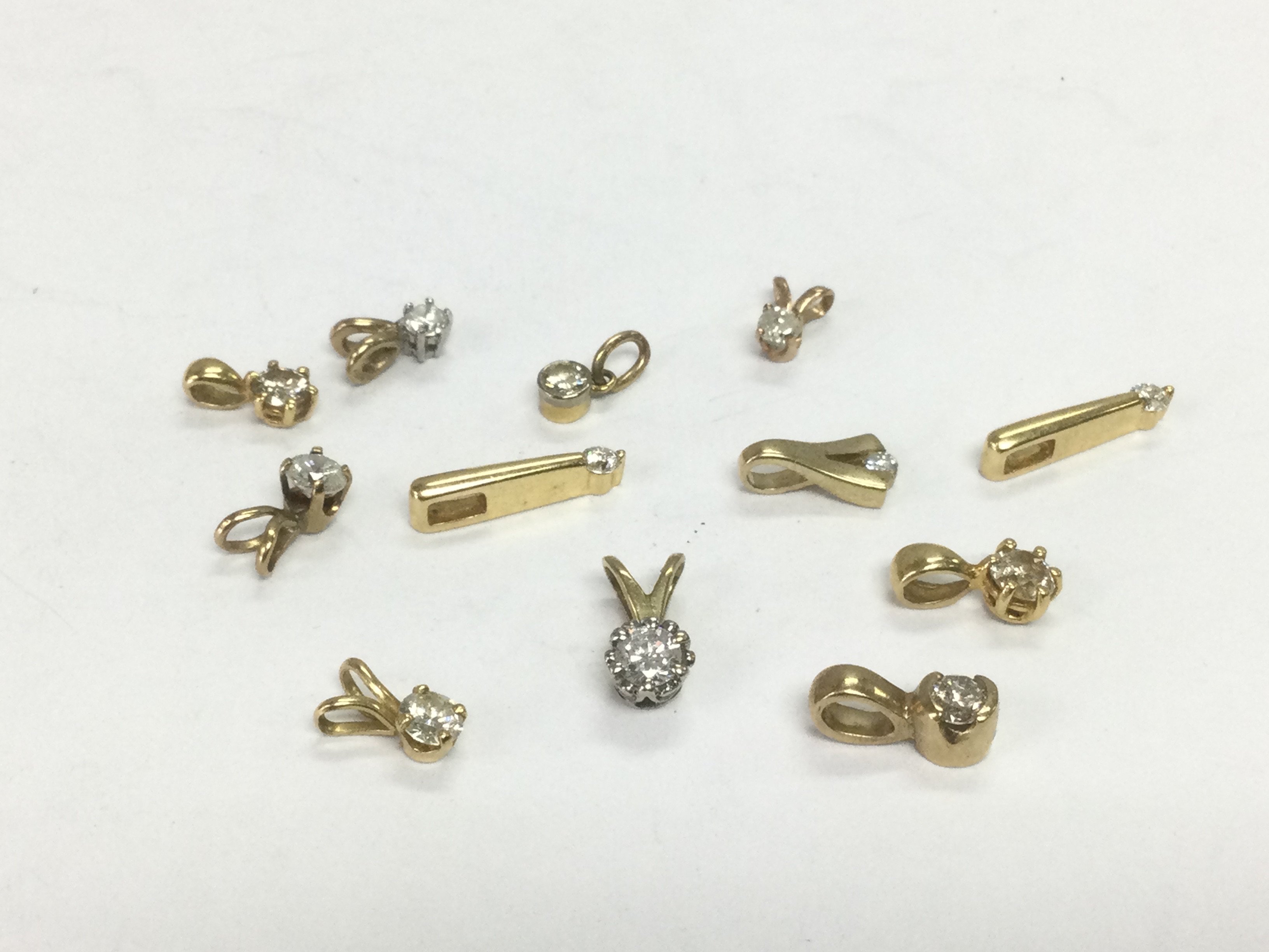 Twelve gold solitaire diamond pendants, total approx 5.8g. Shipping category A.